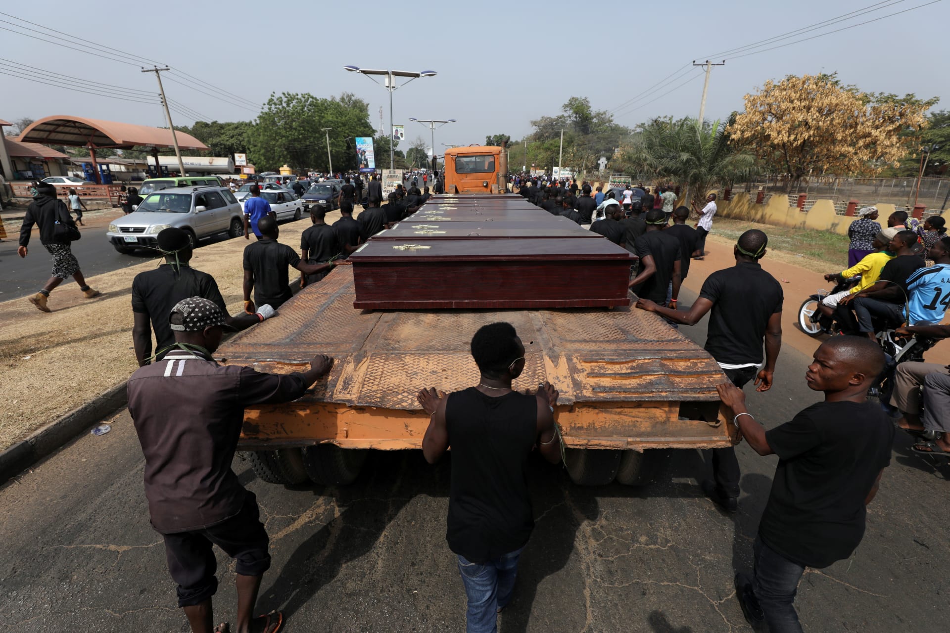 <p>Men march along a truck carrying the coffins of people killed by herdsmen, in Makurdi, Nigeria, January 11, 2018.</p>

