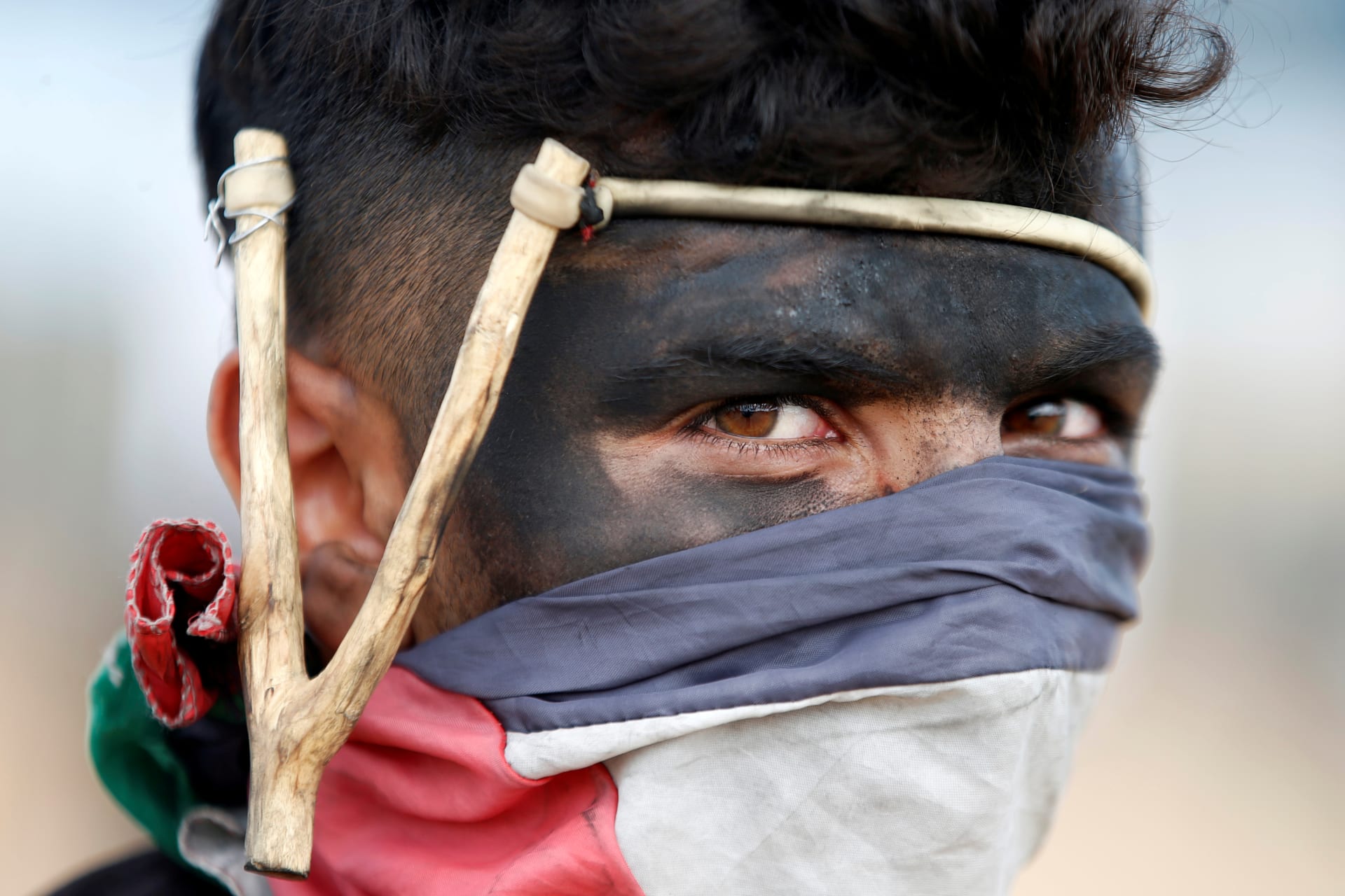 <p>A Palestinian demonstrator with a slingshot looks on during a protest against U.S. embassy move to Jerusalem and ahead of the 70th anniversary of Nakba, at the Israel-Gaza border, east of Gaza City. May 14, 2018.</p>
