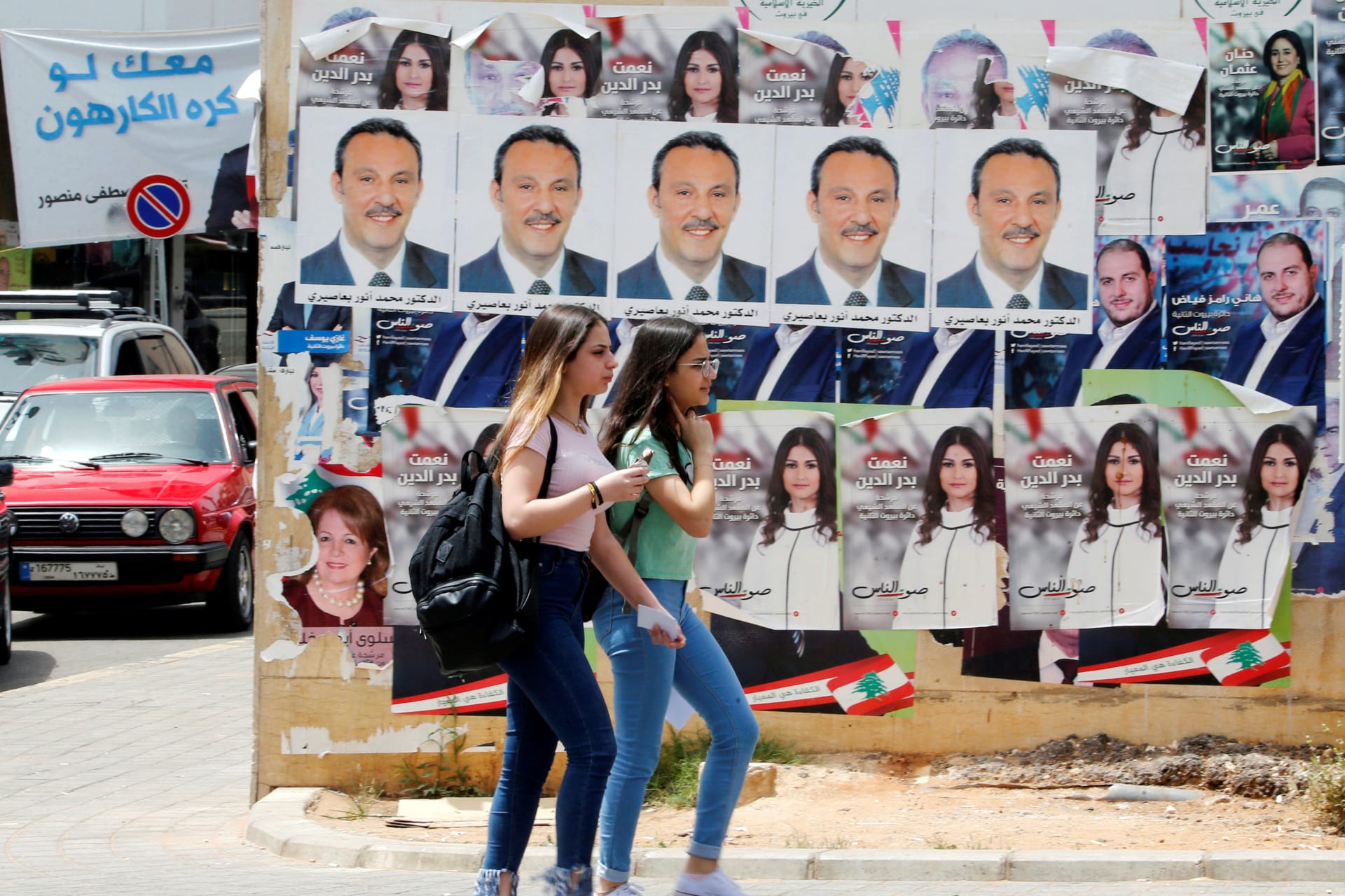 <p>Girls walk past pictures of Lebanese parliament candidates in Beirut.</p>
