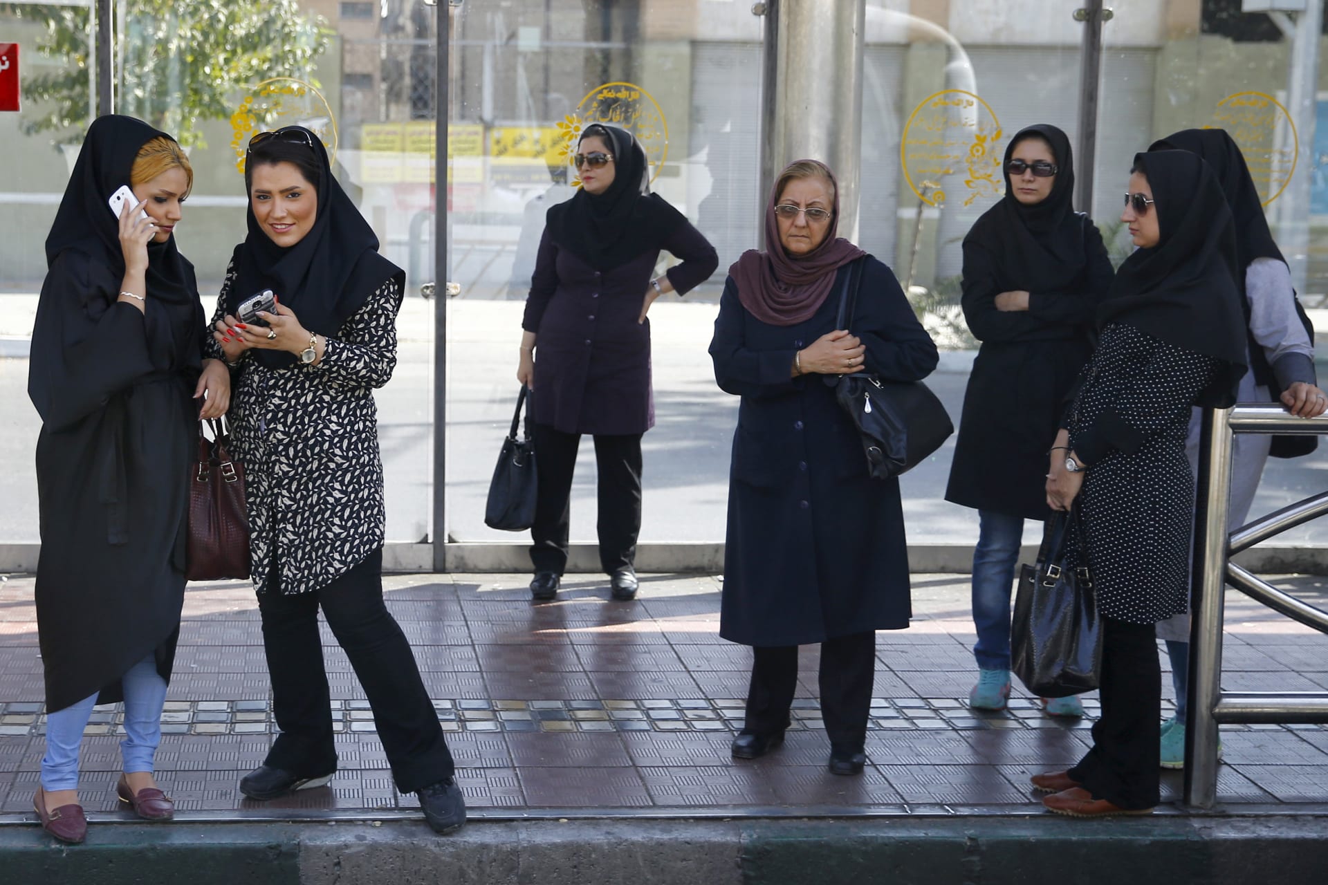 <p>Women wait for a bus in central Tehran, Iran.</p>
