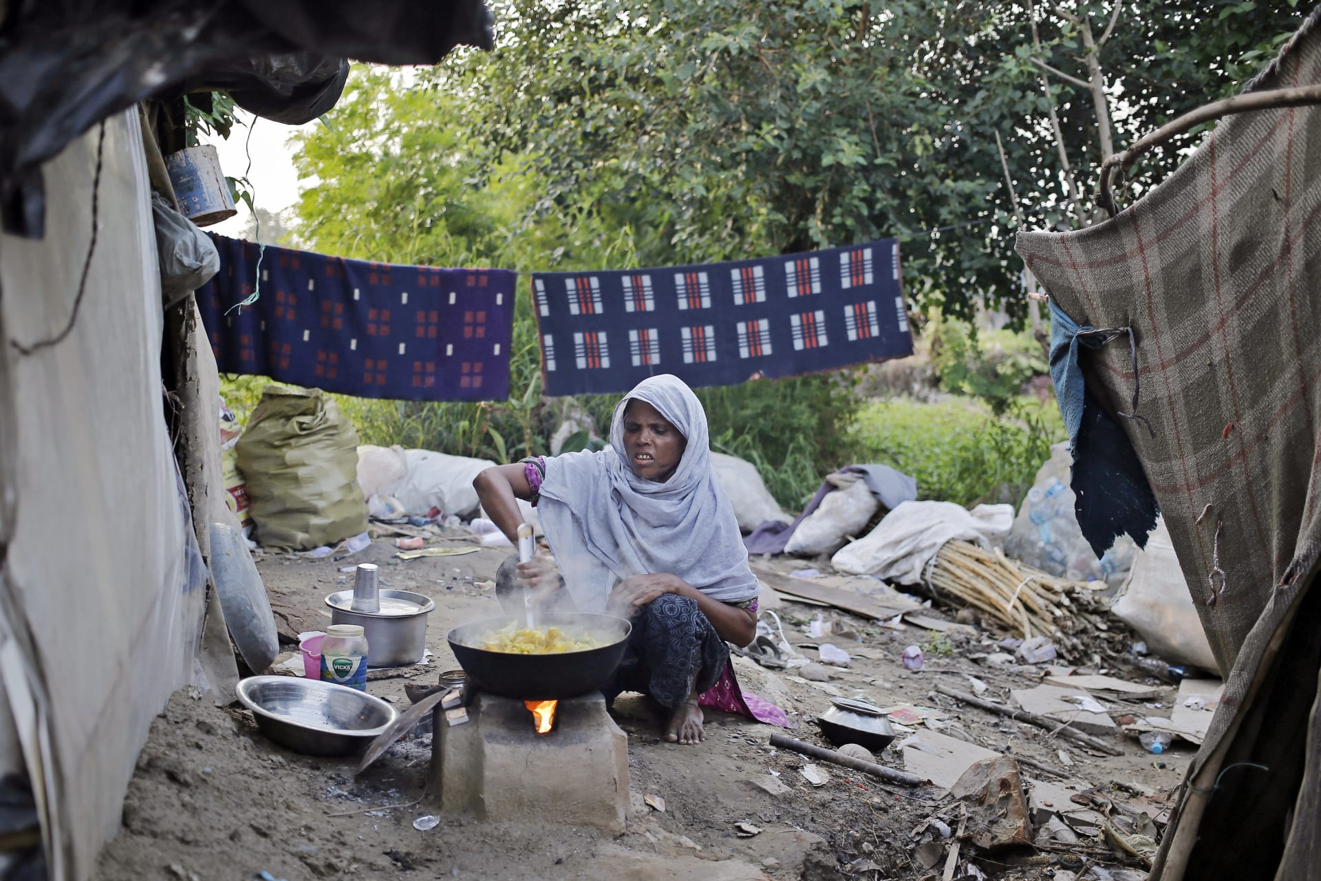 <p>A woman from the Rohingya community from Myanmar cooks food outside her makeshift shelter in a camp in New Delhi, September 13, 2014.</p>
