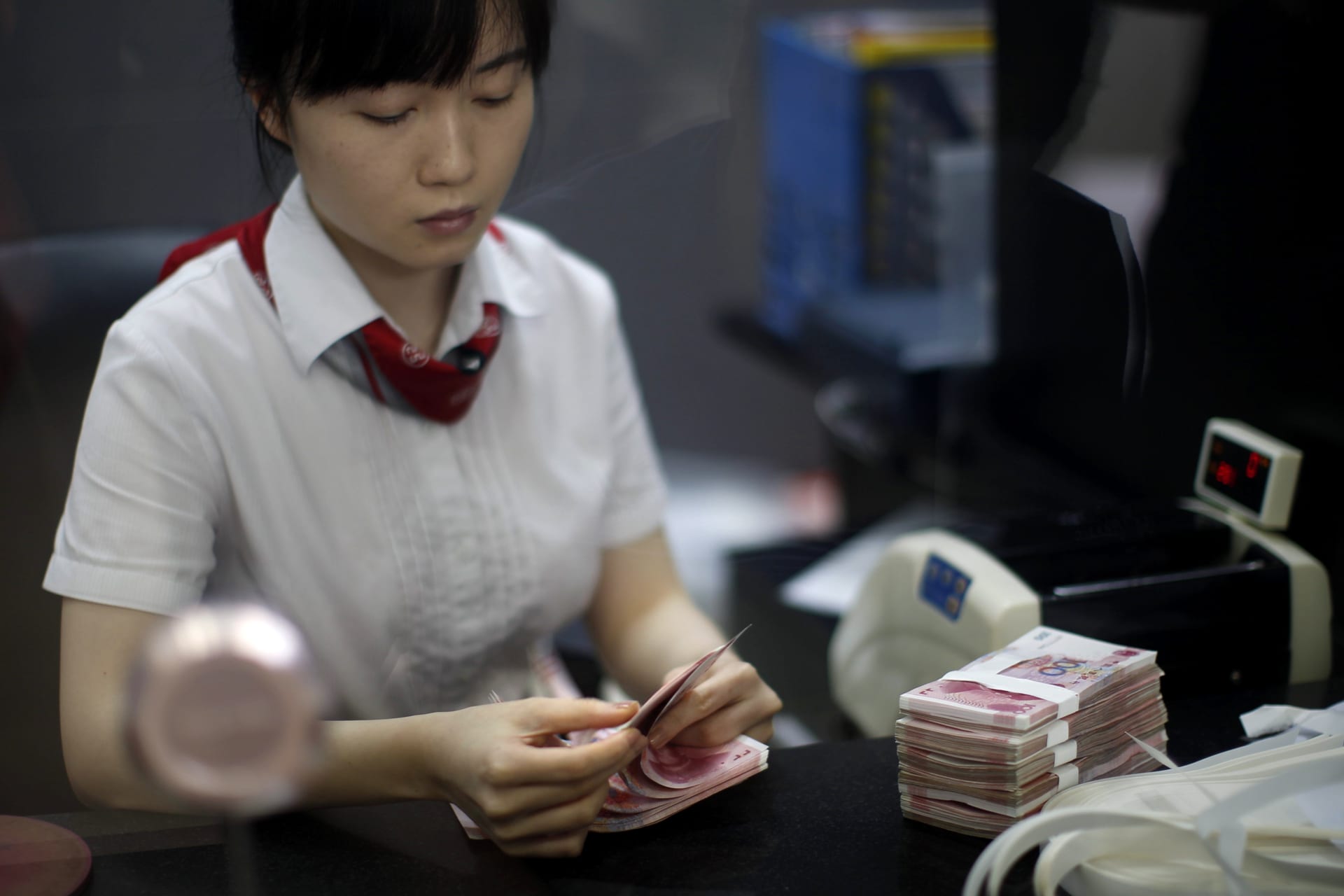 <p>An employee at the Industrial and Commercial Bank of China Ltd counts money at one of the bank’s branches in Pudong district, September 24, 2014.</p>
