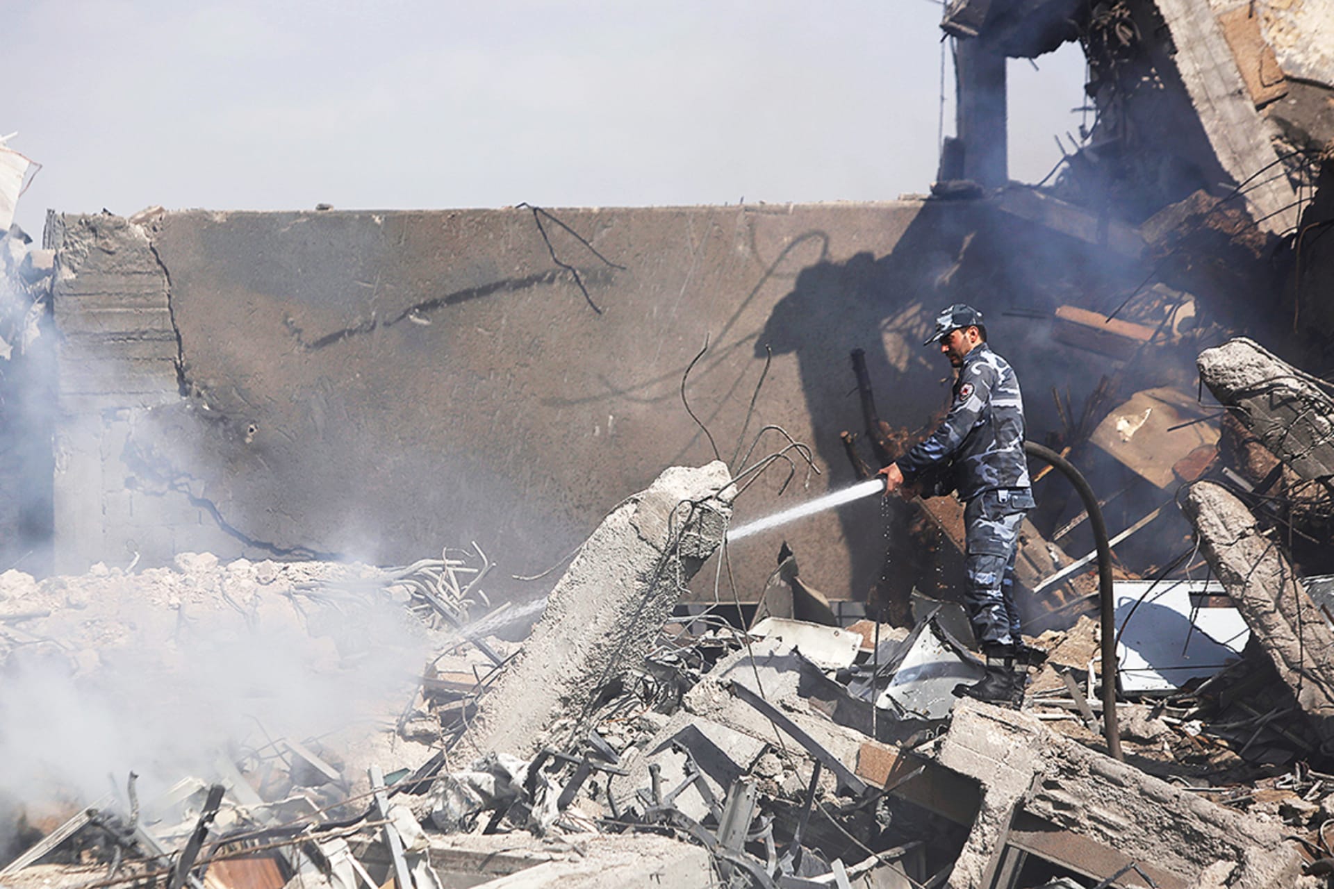 <p>A firefighter works inside the destroyed Scientific Research Center in Damascus.</p>
