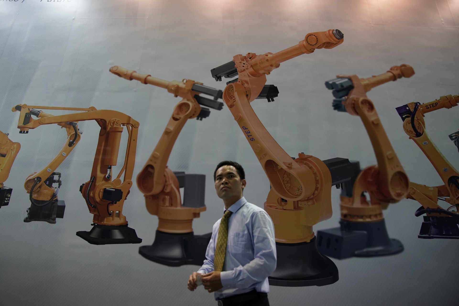<p>A man walks past a billboard at 2017 China International Robot Show in Shanghai</p>
