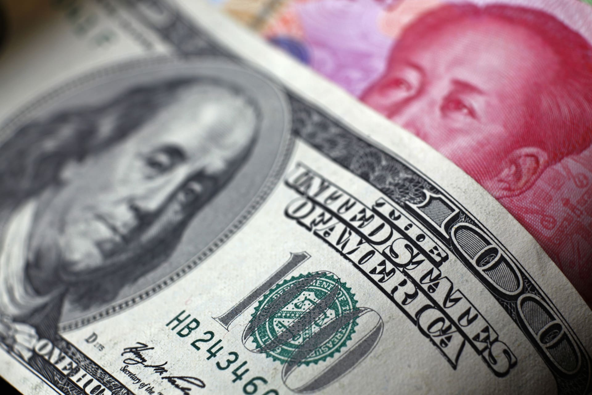 <p>A Chinese 100 yuan banknote is placed under a $100 banknote (top) in this photo illustration taken in Beijing</p>
