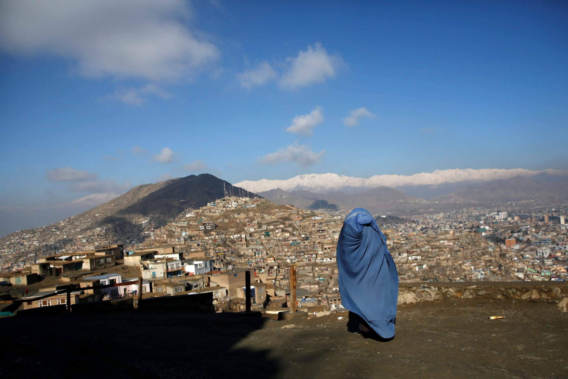 <p>An Afghan woman walks on a hilltop overlooking Kabul, Afghanistan February 27, 2018. </p>
