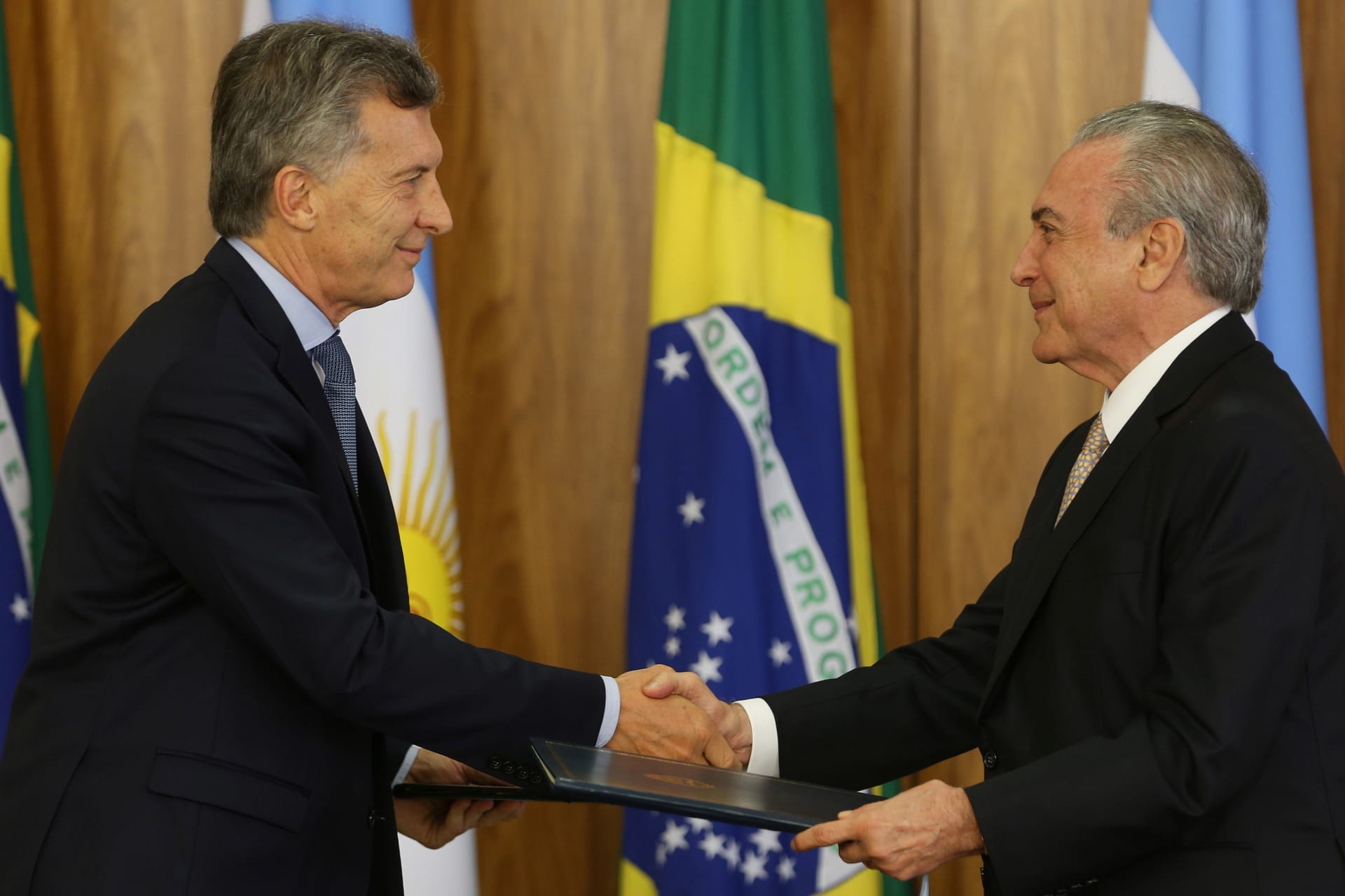 <p>Argentine President Mauricio Macri (L) and his Brazilian counterpart Michel Temer exchange documents after a meeting to discuss closer trade cooperation at the Planalto Palace in Brasilia, Brazil February 7, 2017. </p>
