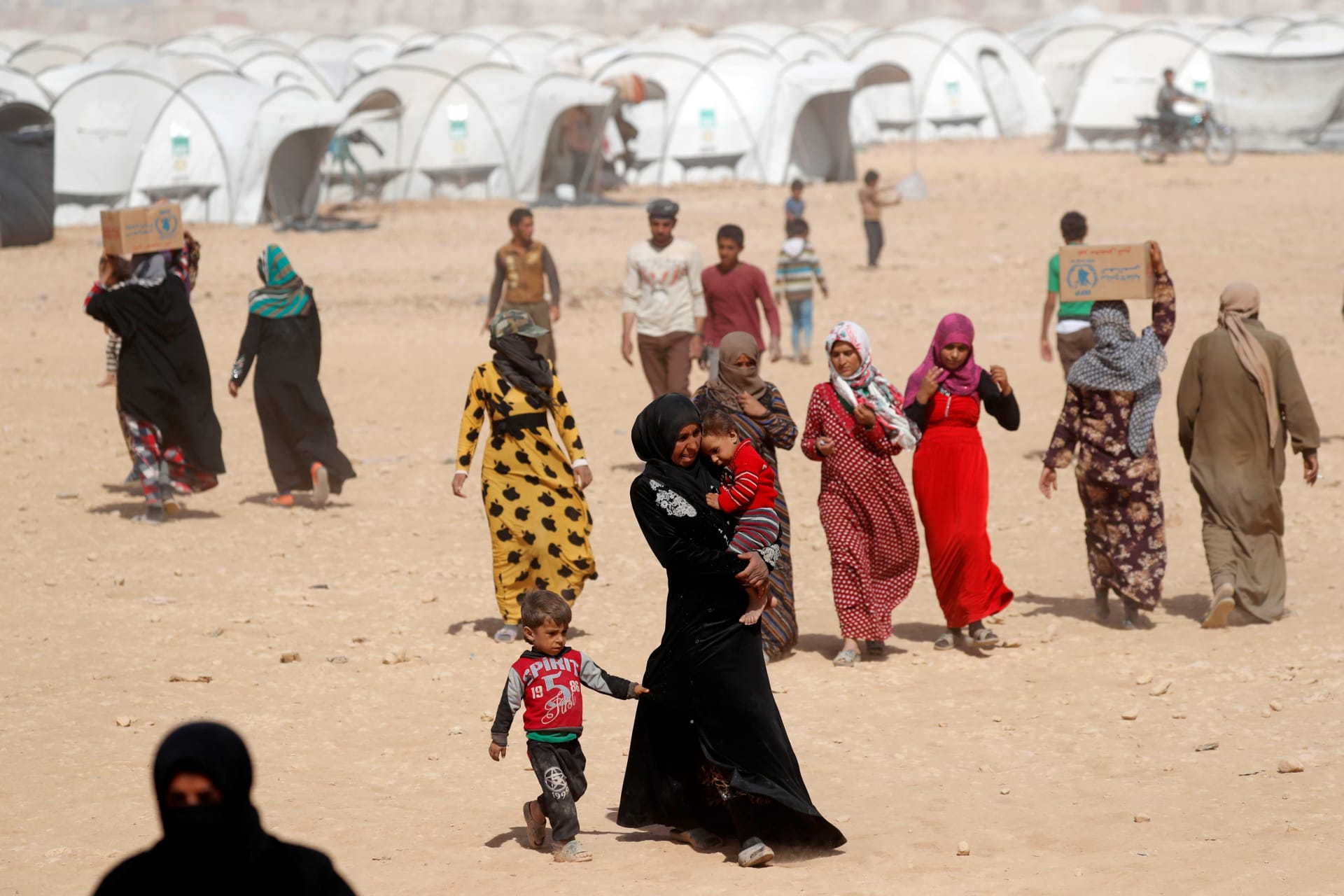 <p>People displaced from fightings between the Syrian Democratic Forces and Islamic State militants carry boxes of food aid given by UN’s World Food Programme at a refugee camp in Ain Issa, Syria October 10, 2017. </p>