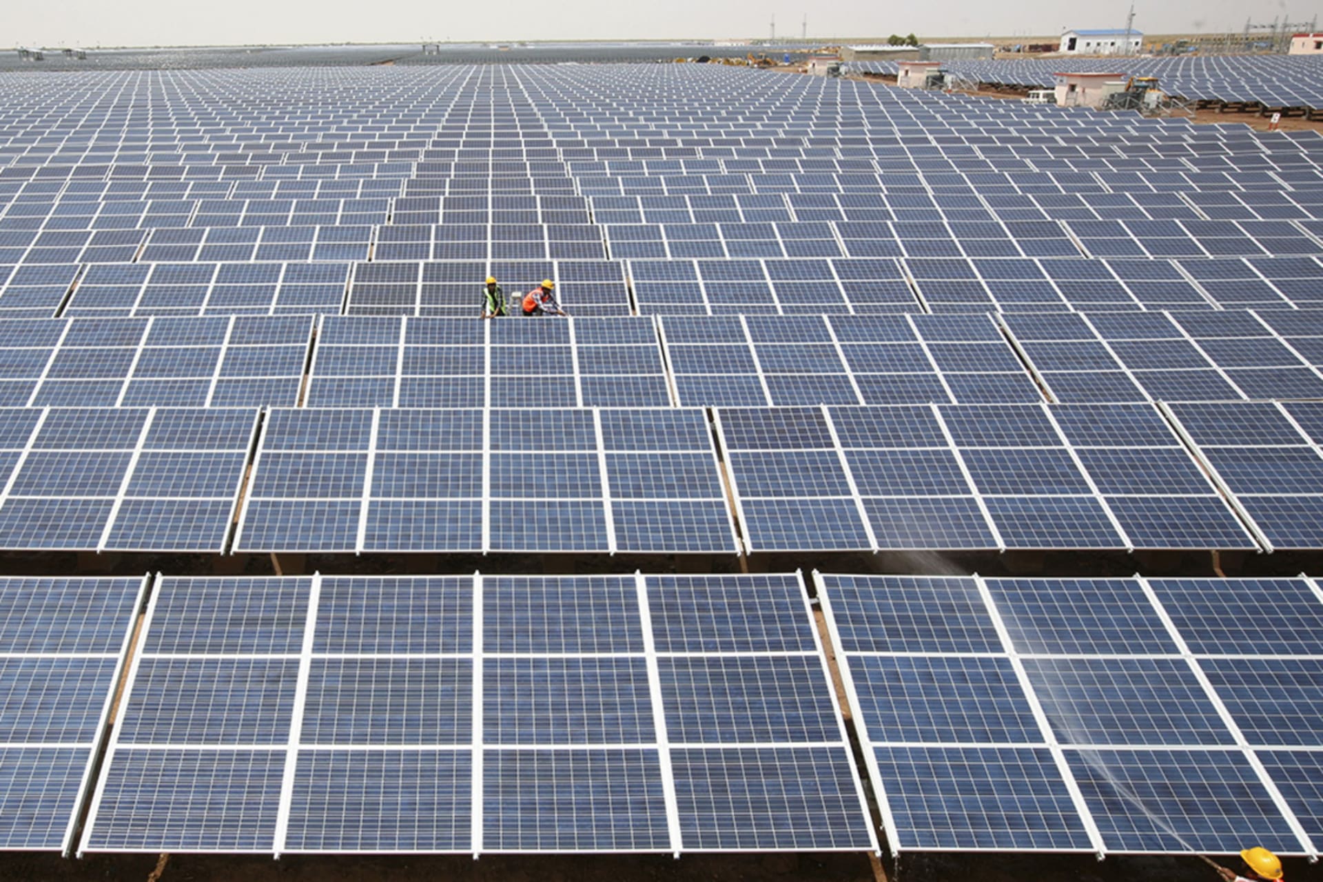 <p>Workers install photovoltaic solar panels at the Gujarat solar park under construction in Charanka village, in Patan district of the western Indian state of Gujarat, India, April 14, 2012.</p>
