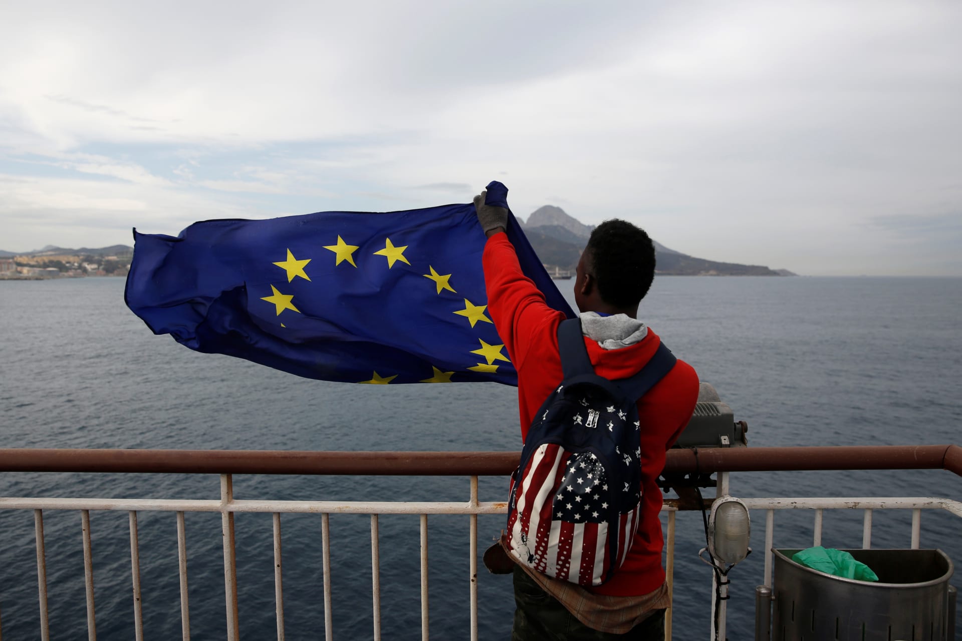 <p>An African migrant holds a European Union flag on board a ferry to Algeciras after having awaited in CETI, the short-stay immigrant centre in Spain’s north African enclave of Ceuta to be transferred to mainland Spain, February 23, 2017.</p>
