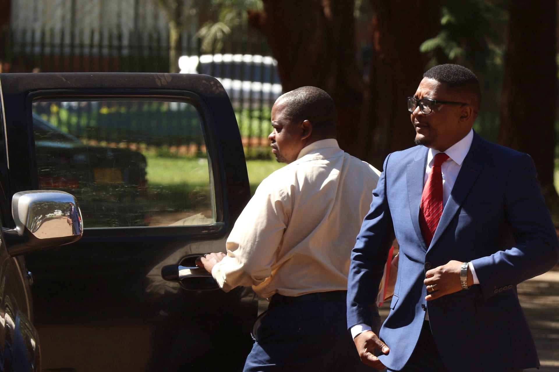 <p>Former Minister of Foreign Affairs Walter Mzembi is escorted by a detective during his appearance at the Harare Magistrates Court in Harare, Zimbabwe, January 6, 2018. </p>
