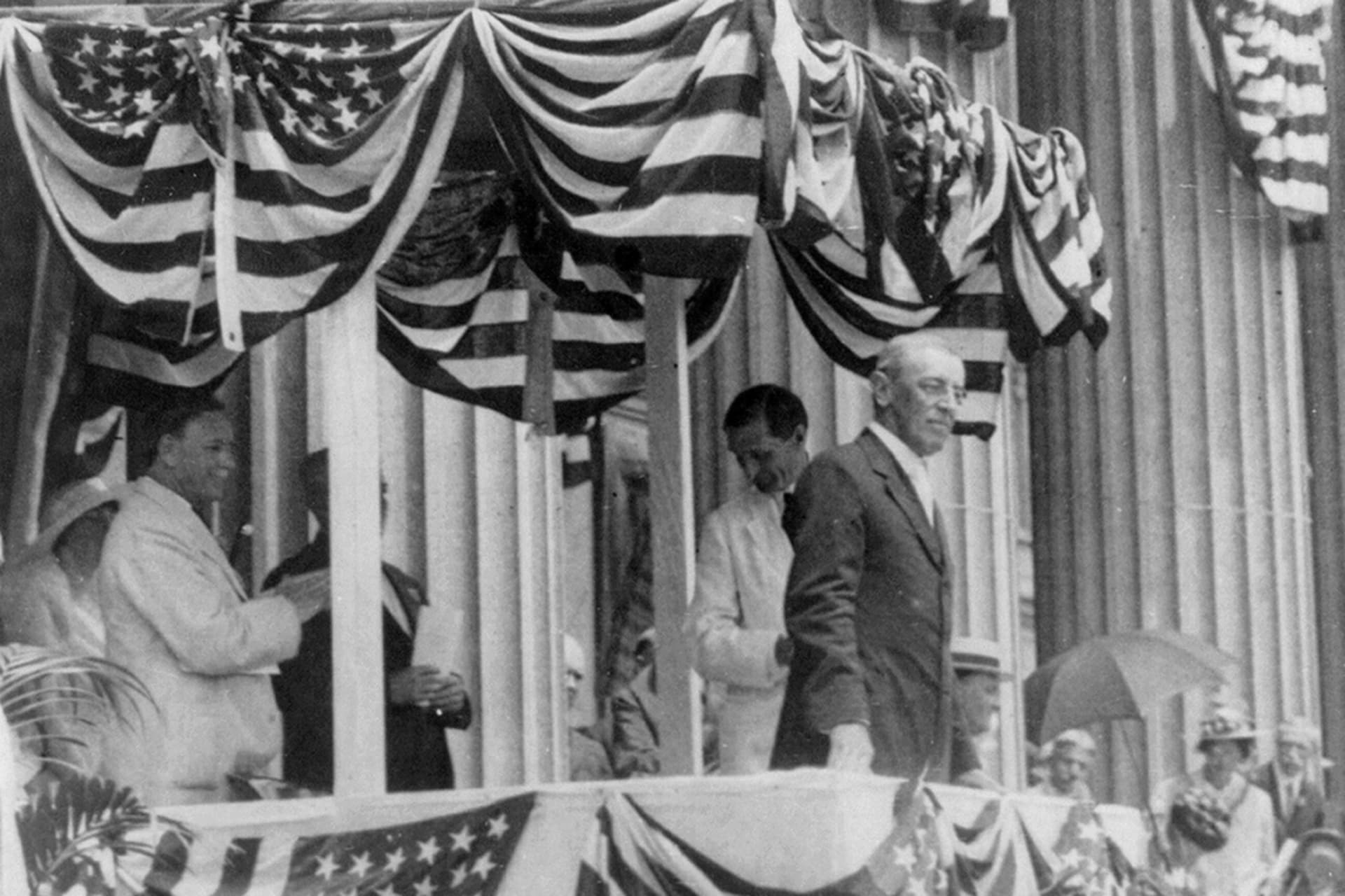 <p>Woodrow Wilson standing on a flag-bedecked podium on Flag Day, May 1915. </p>
