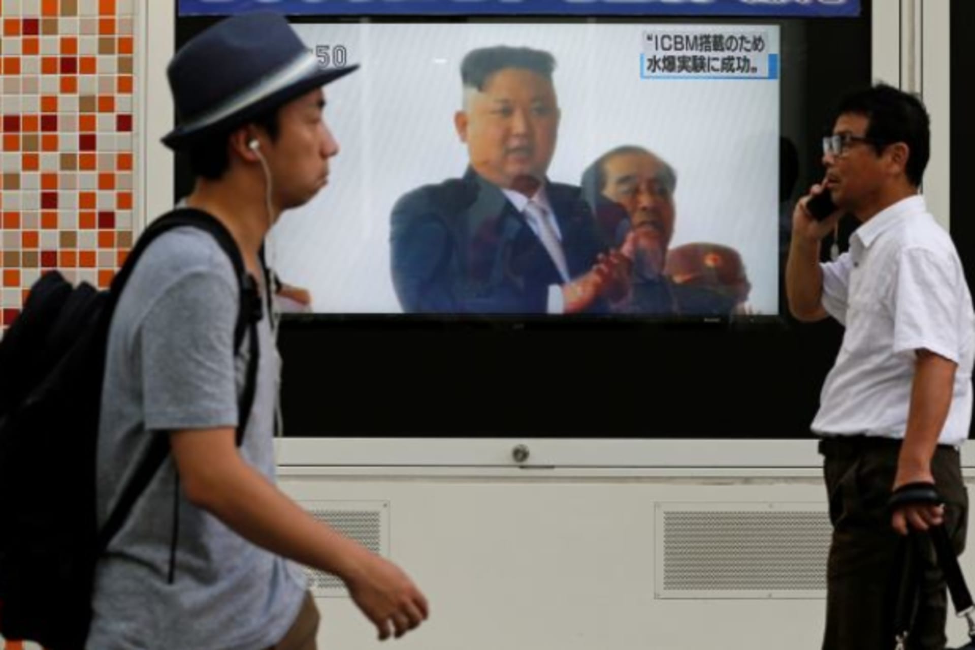 <p>Men walk past a street monitor showing North Korea’s leader Kim Jong-Un in a news report about North Korea’s nuclear test, in Tokyo, Japan, September 3, 2017.</p>
