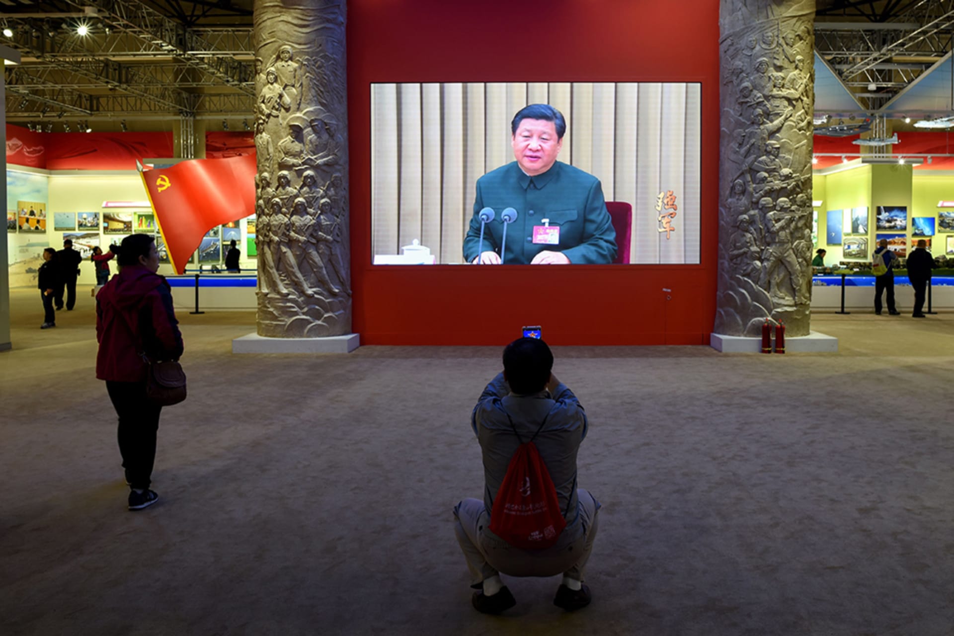 <p>A man takes a picture of a screen showing Chinese President Xi Jinping in October 2017.</p>
