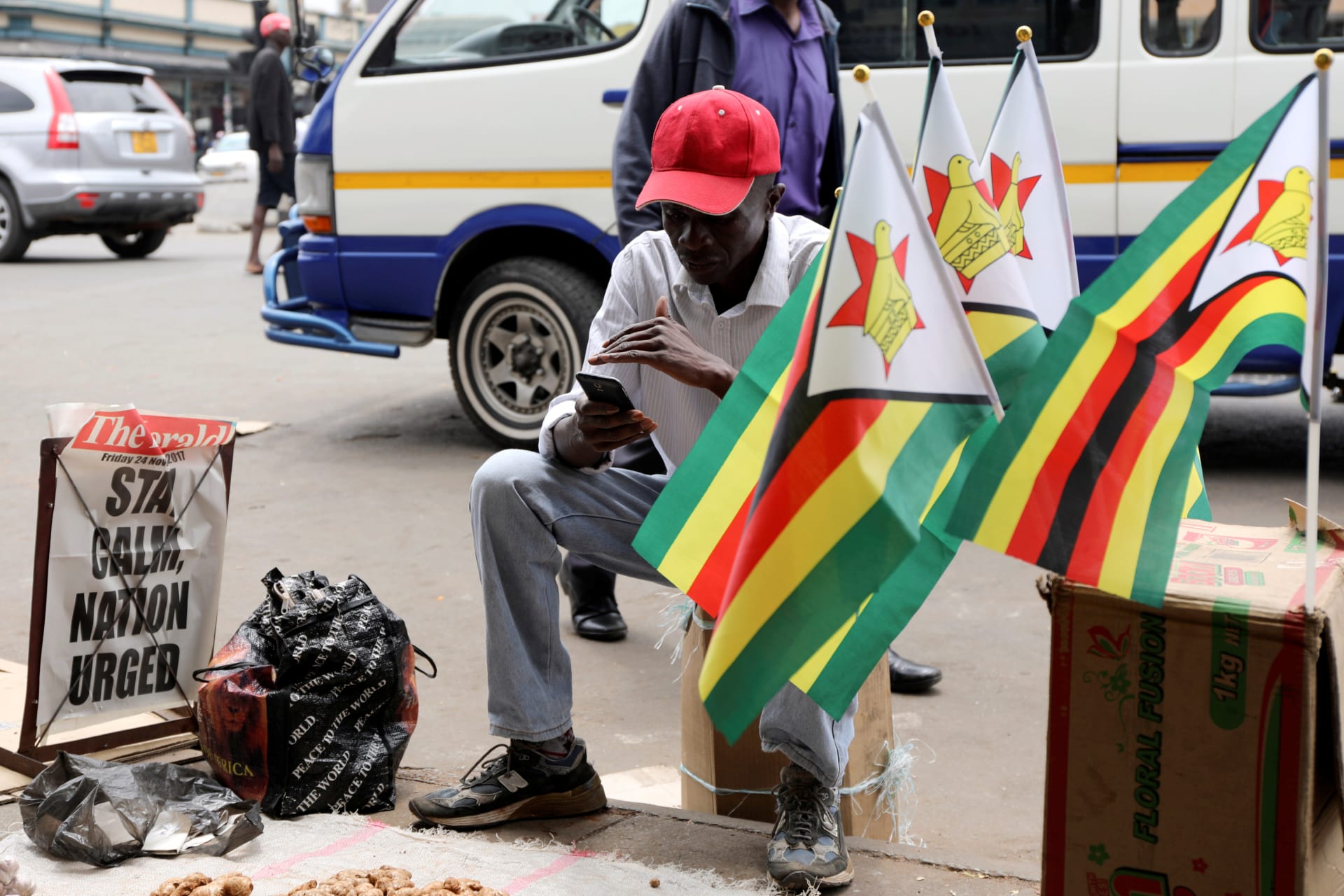 <p>A street vendor watches Emmerson Mnangagwa’s presidential inauguration ceremony on his mobile phone in Harare, Zimbabwe, November 24, 2017. </p>
