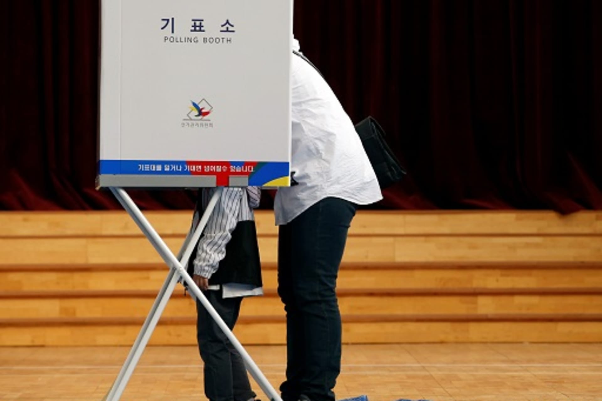 <p>A parent and child in the voting booth during South Korea’s 2017 presidential election. </p>