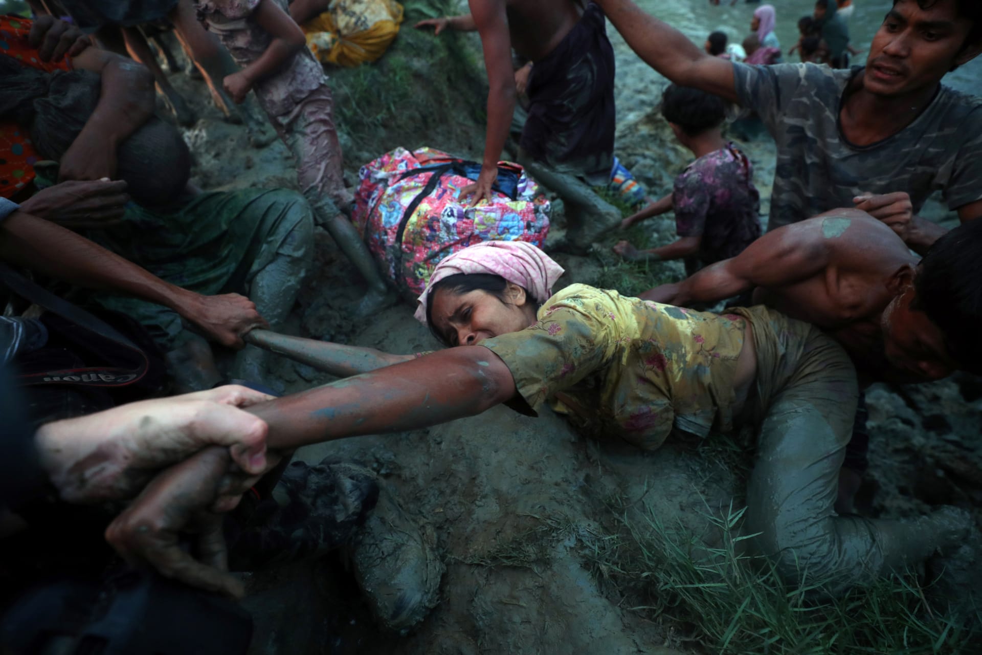 <p>Photographers help a Rohingya refugee to come out of Naf River as they cross the Myanmar-Bangladesh border in Palong Khali, Bangladesh on November 1, 2017.</p>
