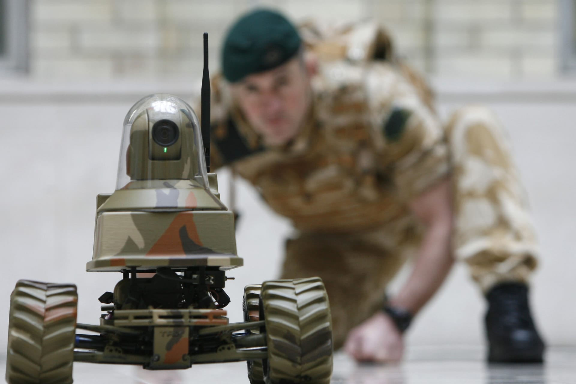 <p>A Royal Marine poses for photographers with the Unmanned Vehicle Robot, Testudo, at the launch of the Defense Technology Plan in London on February 26, 2009. </p>

