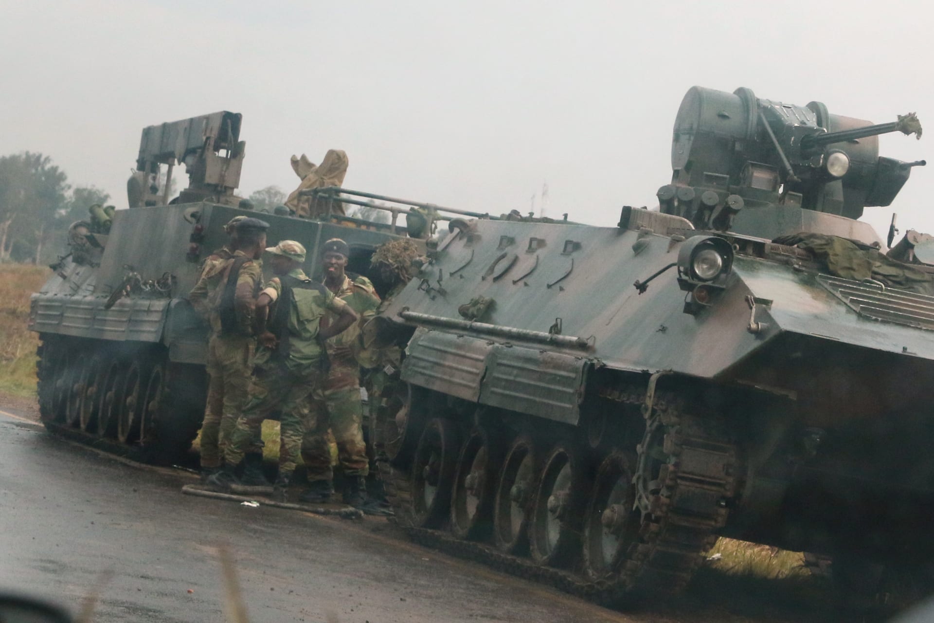 <p>Soldiers stand beside military vehicles just outside Harare, Zimbabwe’s capital, November 14, 2017.</p>
