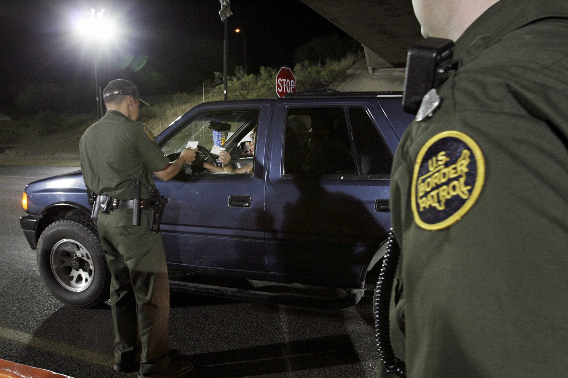 <p>A U.S. Border Patrol agent checks the identification of a motorist at a checkpoint 20 miles north of the United States and Mexican border near Tubac, Arizona.</p>
