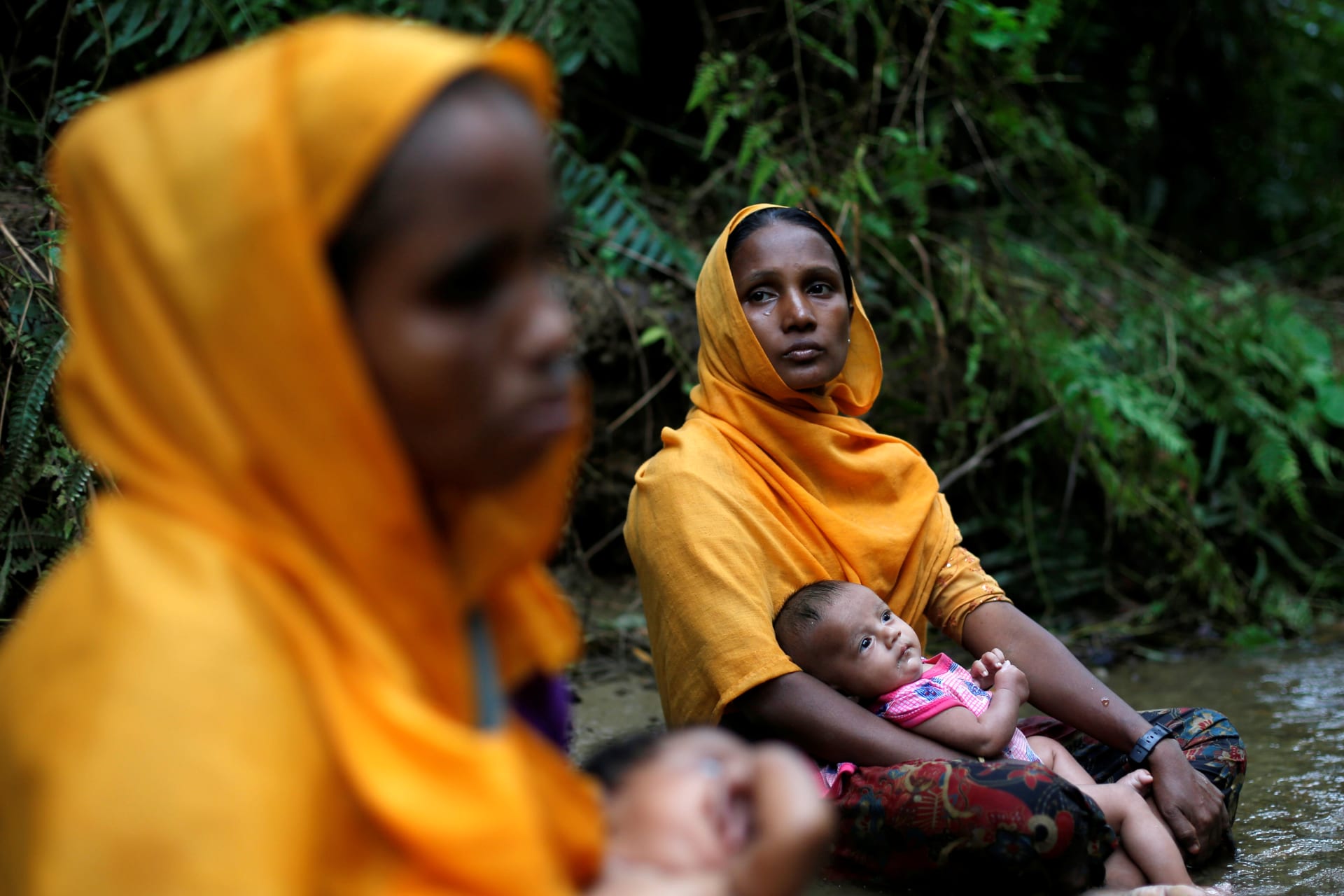 <p>Rohingya women sit with infants by a river near Cox Bazaar, a sprawling refugee camp for Rohingya Muslim minorities fleeing attacks on villages and sexual violence in Myanmar.</p>