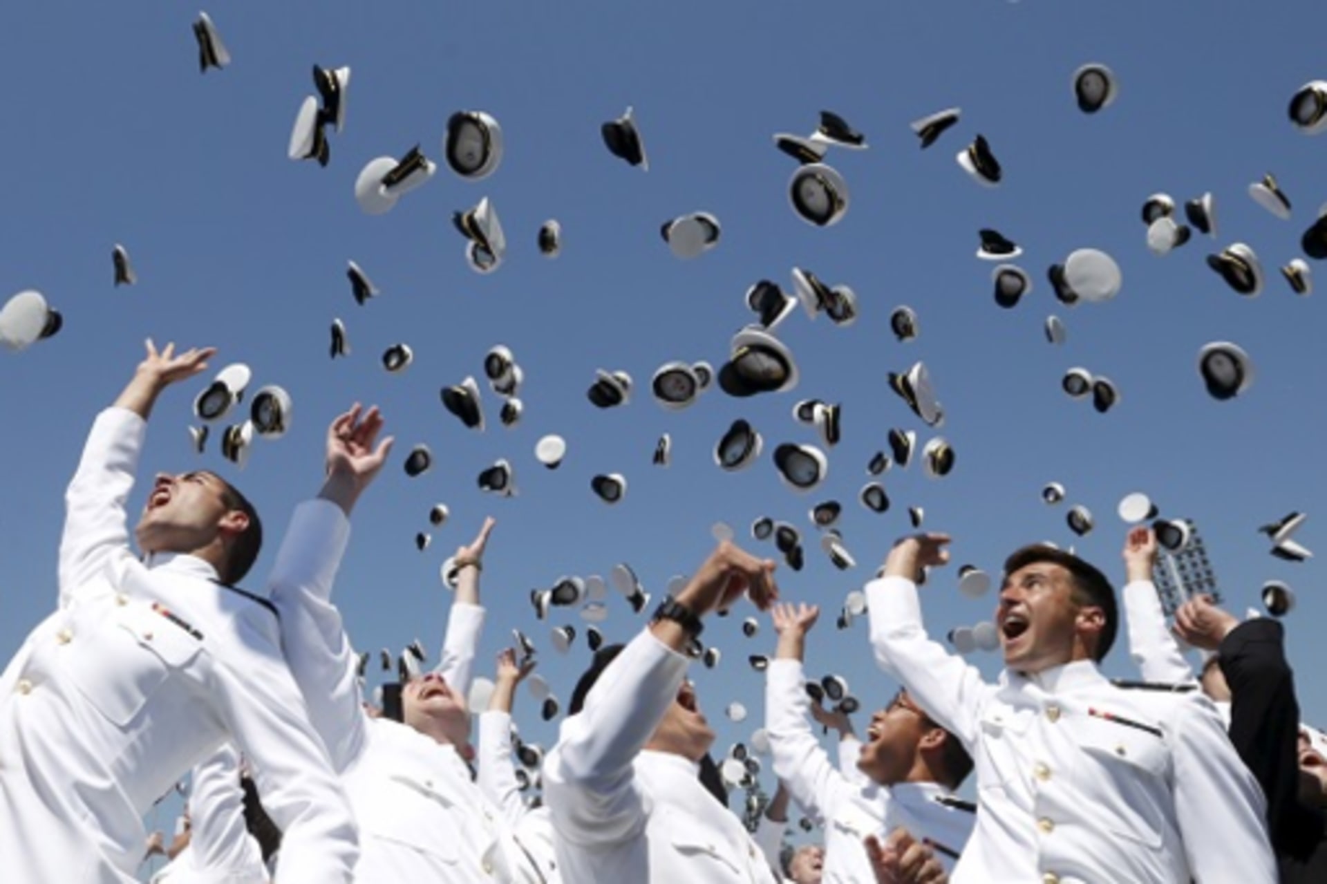 <p>U.S. Naval Academy graduates toss their caps in the air. </p>
