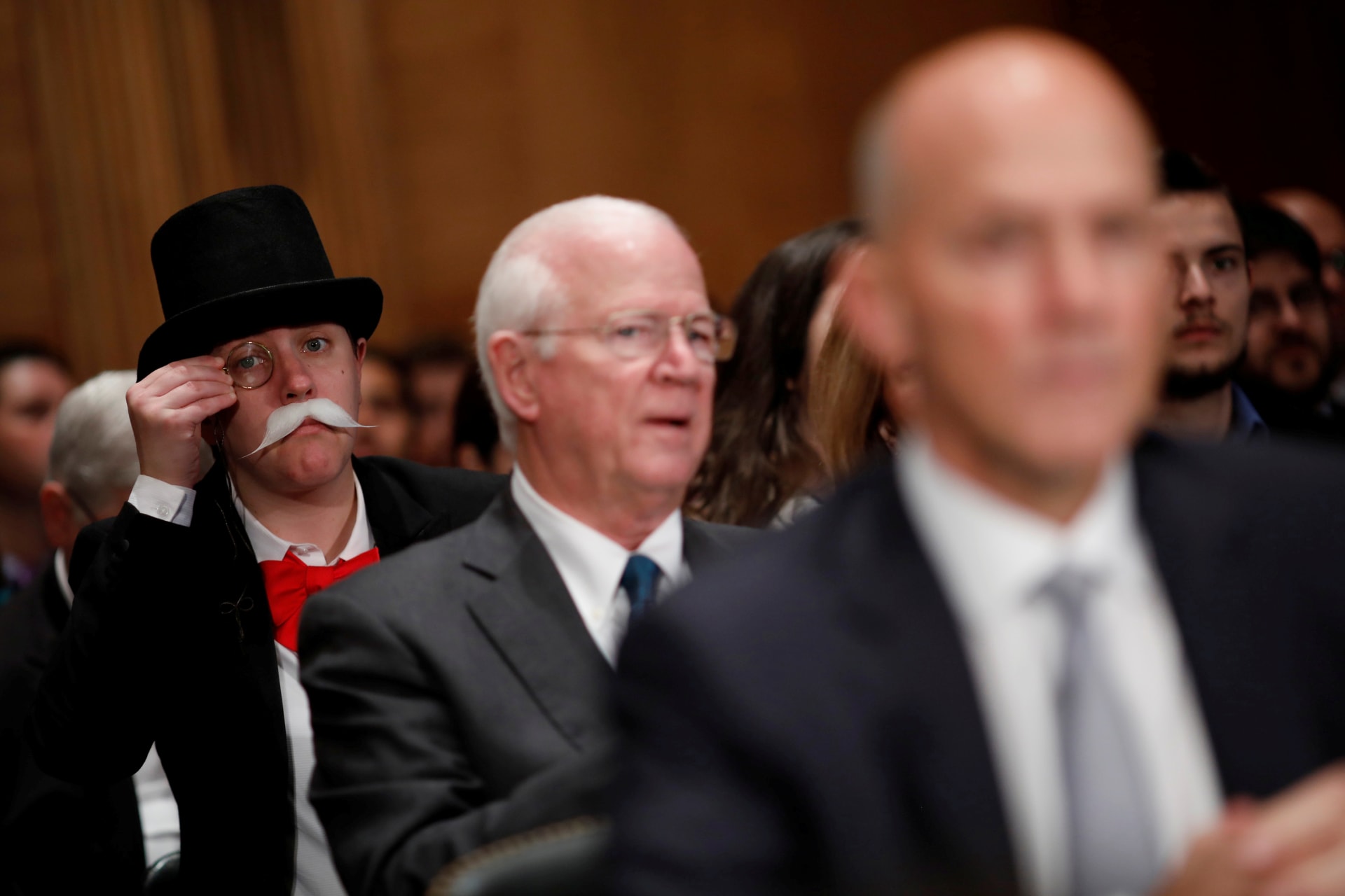 <p>A hearing attendee looks on as Richard Smith, former chairman and CEO of Equifax, Inc., testifies before the U.S. Senate Banking Committee on Capitol Hill on October 4, 2017.</p>
