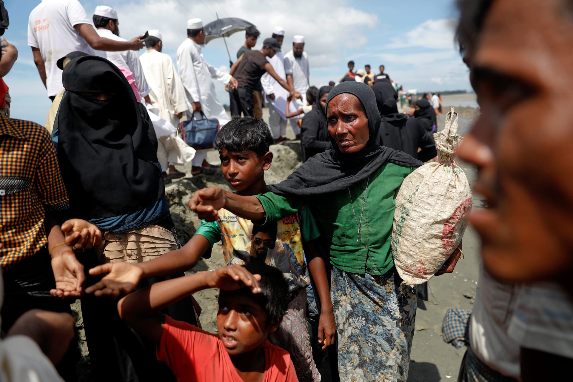 <p>Rohingya refugees who just arrived by wooden boats from Myanmar reach out to receive some aid Teknaf, near Cox’s Bazar in Bangladesh, October 3, 2017.</p>
