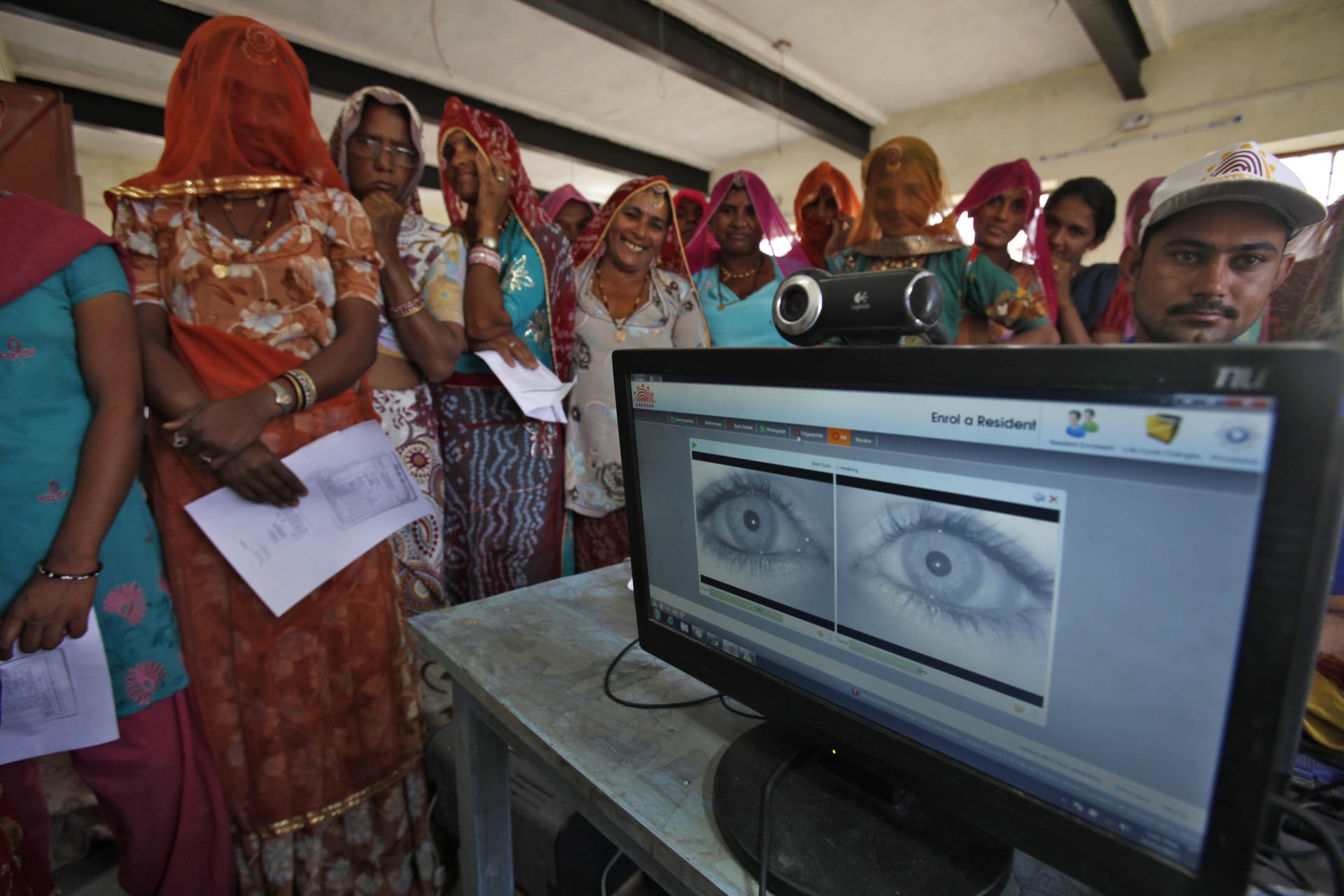 <p>Village women stand in a queue to get themselves enrolled for Aadhaar, a controversial identification database in February 2013.</p>
