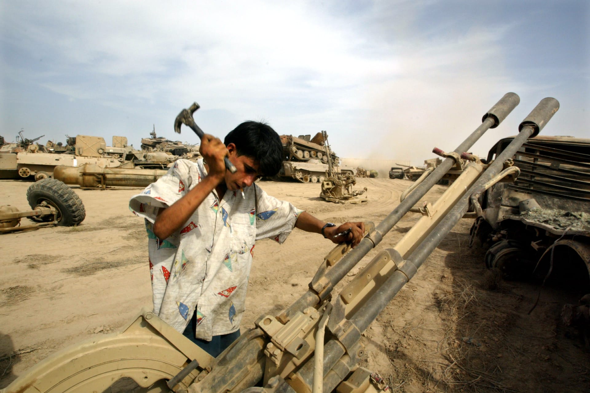 <p>An Iraqi man recovers metal parts from an anti-aircraft gun in a wreckage dump on the outskirts of Baghdad (Jamal Saidi/Reuters).</p>
