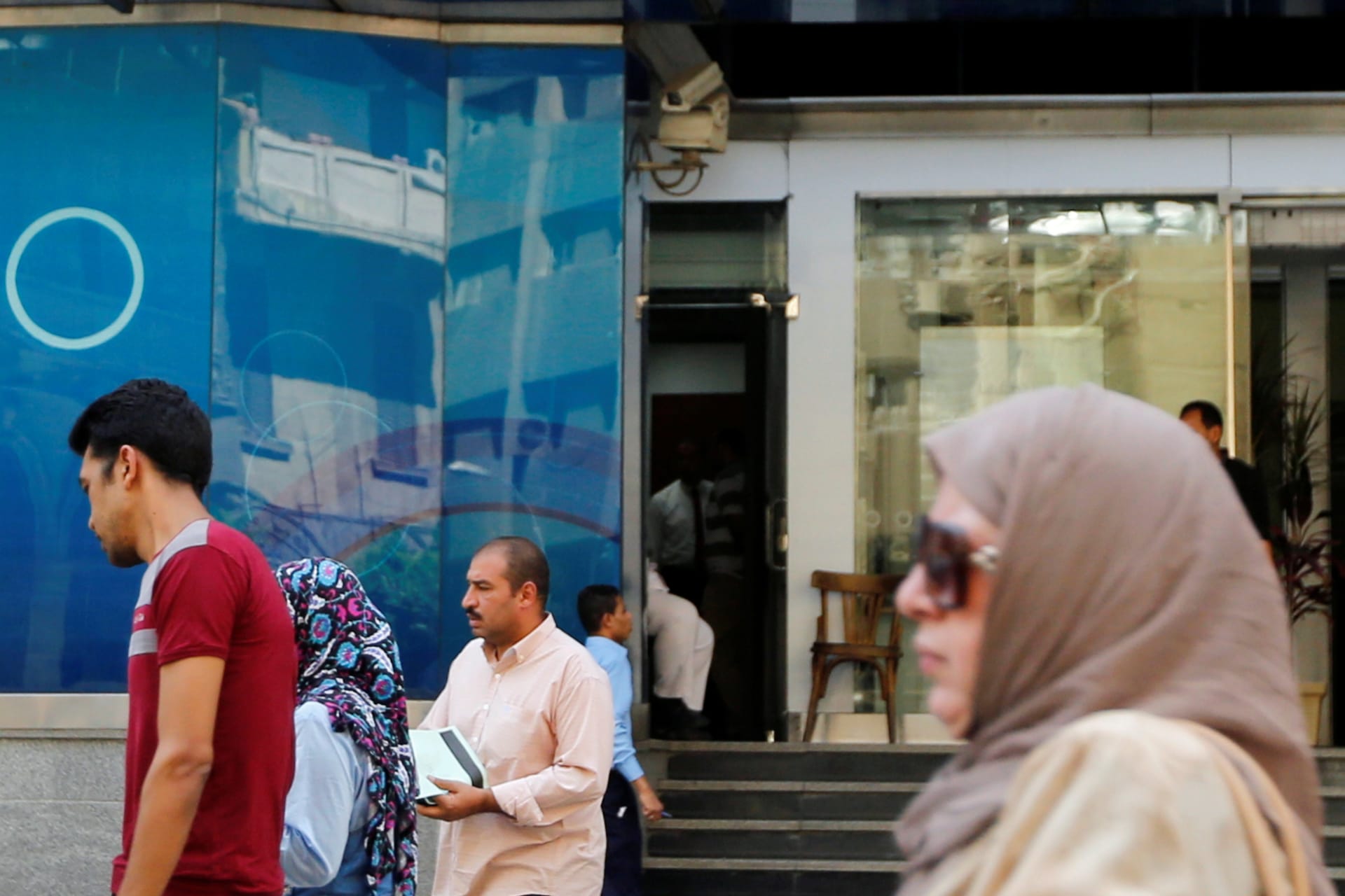 <p>People walk in front of Arab Bank in downtown Cairo, Egypt July 25, 2017.</p>
