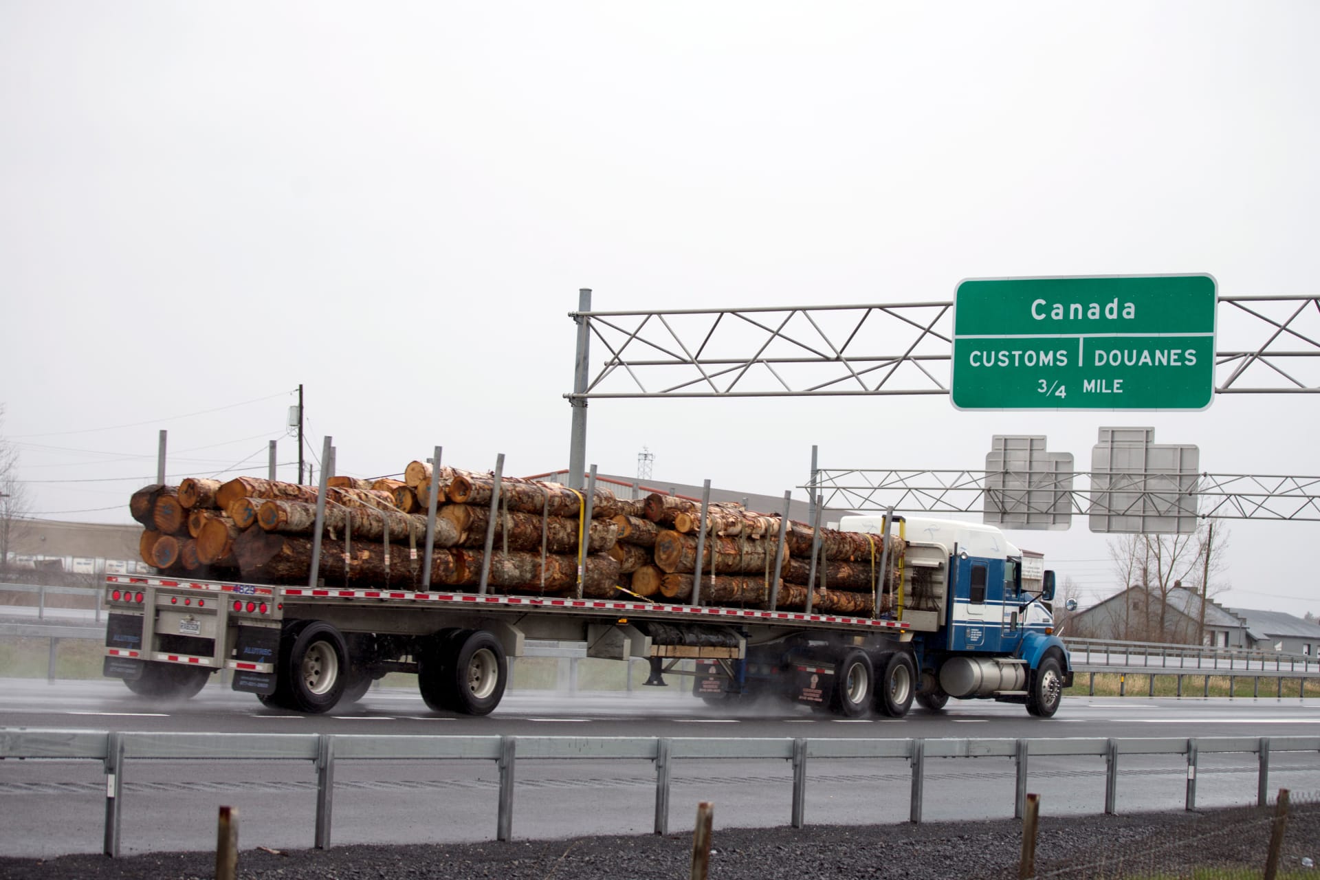 <p>A truck carrying logs heads toward the Canada border in Champlain, New York.</p>
