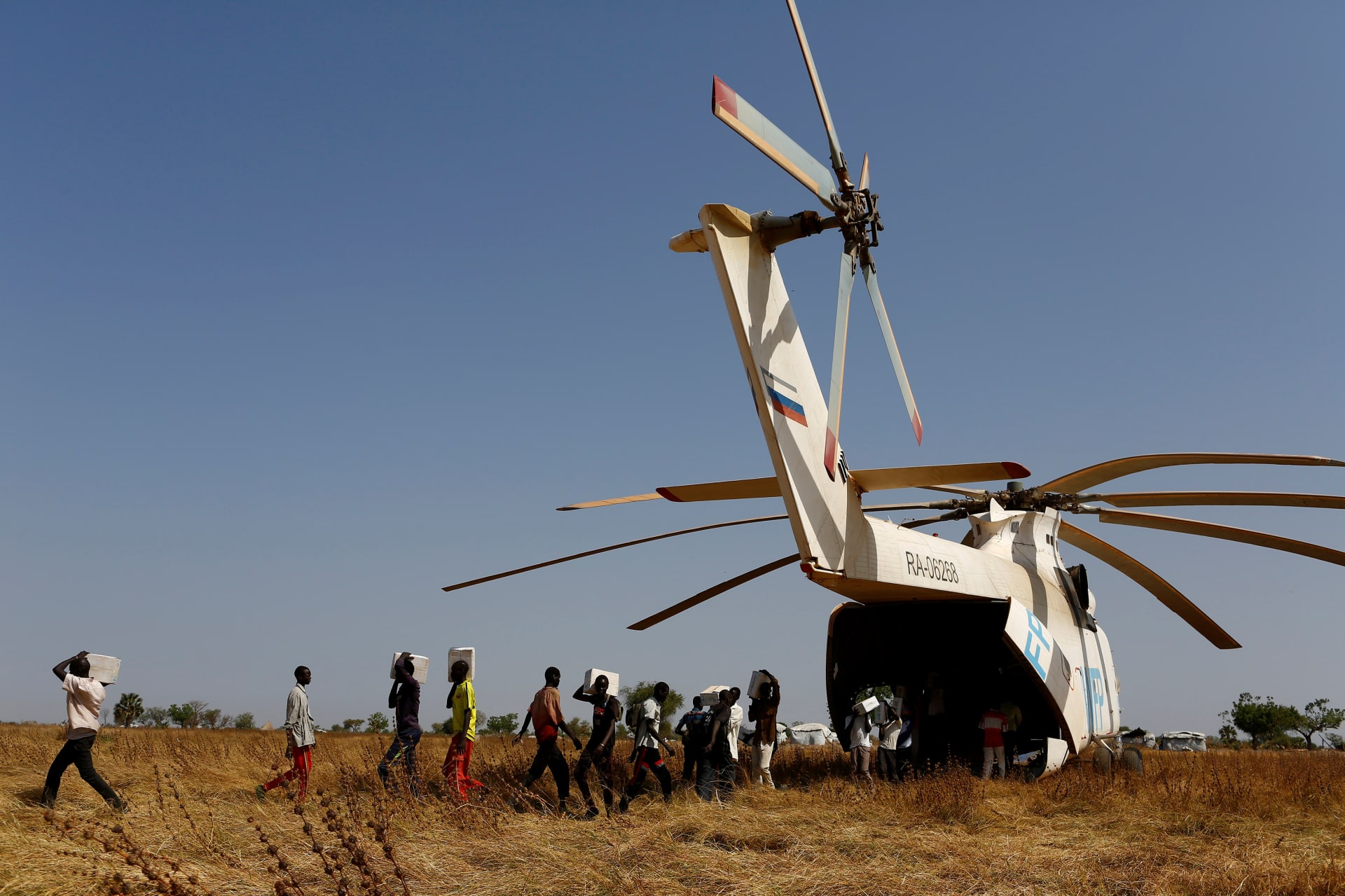 <p>Men unload boxes of nutritional supplements from an helicopter prior to a humanitarian food distribution carried out by the United Nations World Food Programme (WFP) in Thonyor, Leer county, South Sudan, February 25, 2017.</p>
