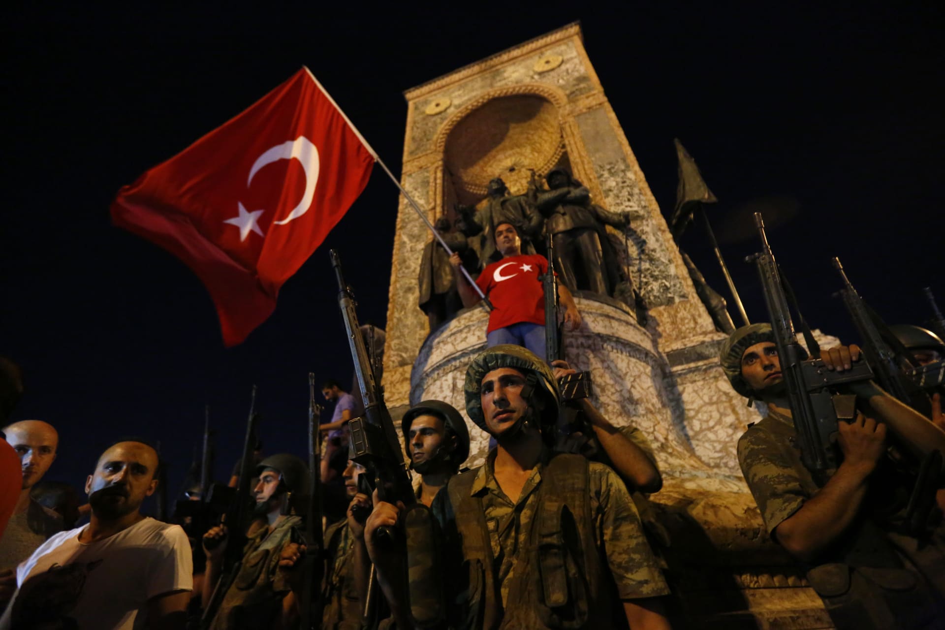 <p>Turkish military stand guard near the the Taksim Square as people wave with Turkish flags in Istanbul (Murad Sezer/Reuters).</p>
