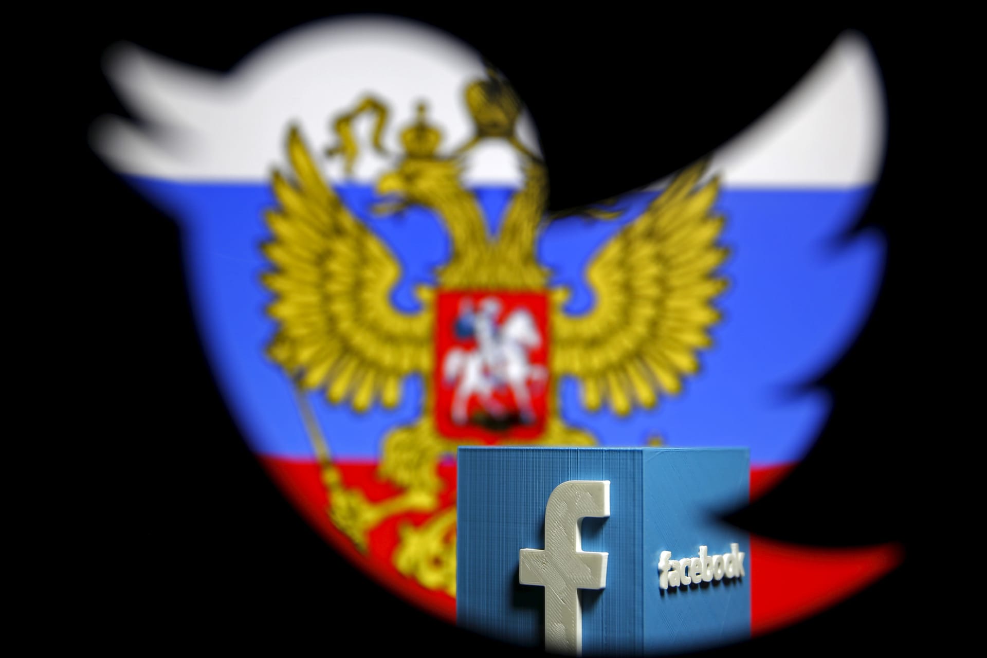 <p>A Russian flag and a 3D model of the Facebook logo is seen through a cutout of the Twitter logo in a photo illustration.</p>
