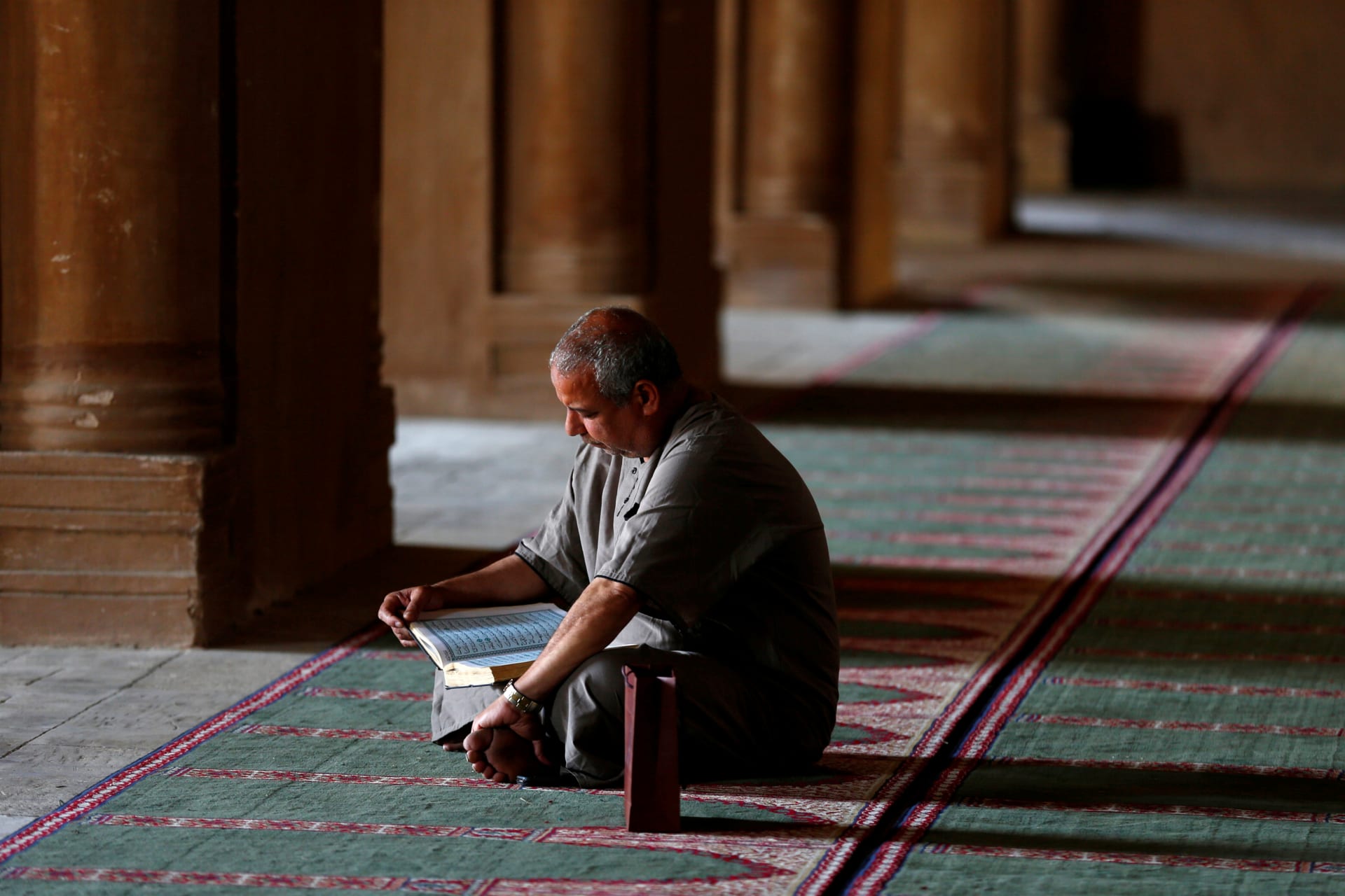 <p>An Egyptian man reads the Koran during the first Friday of the holy month of Ramadan at Ibn Tulun Mosque in old Cairo (Amr Abdallah Dalsh/Reuters).</p>

