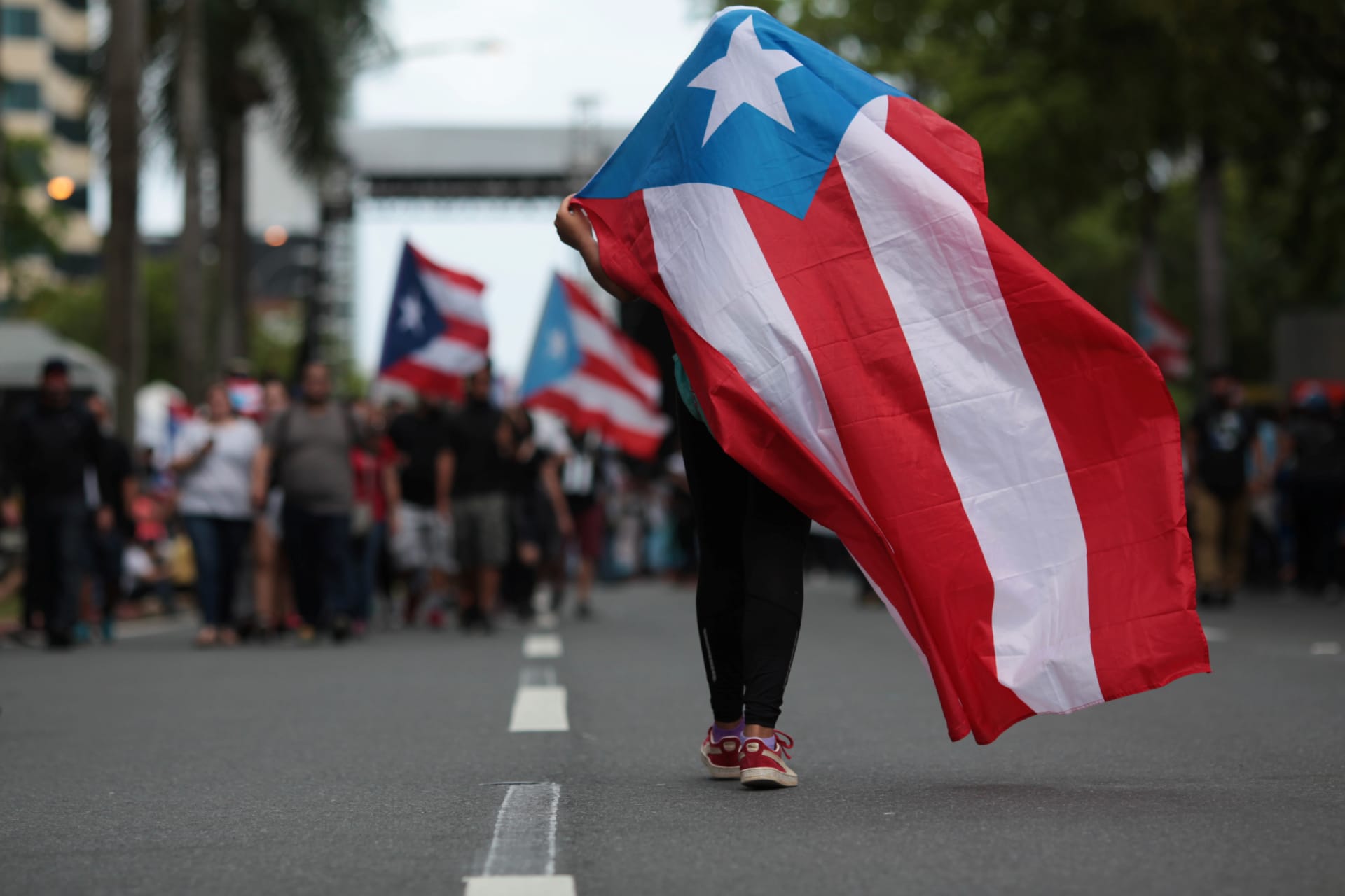<p>A protester carries a Puerto Rican flag during a rally opposing the government’s austerity measures.</p>
