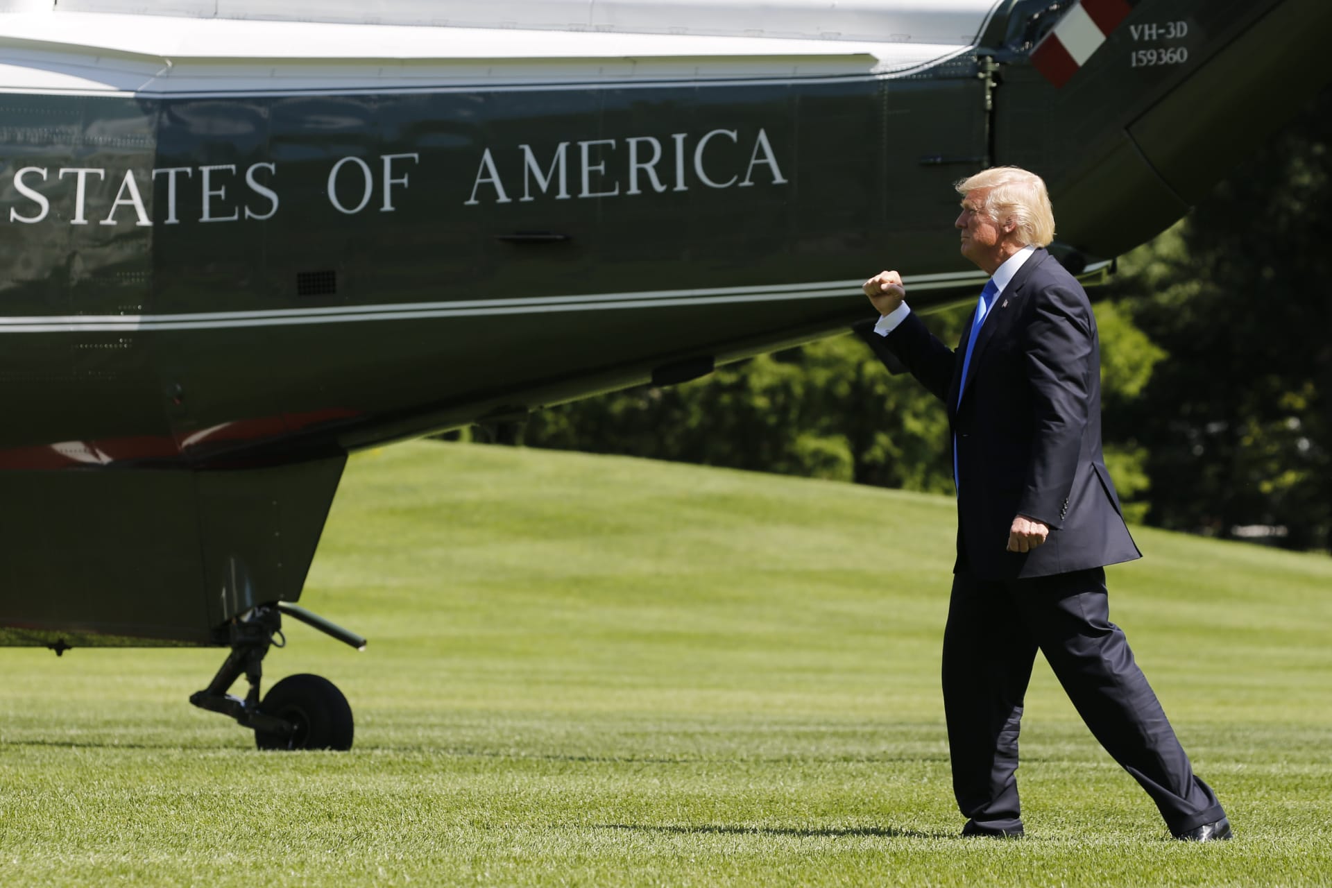 <p>U.S. President Donald Trump pumps his fist at his aides and staff members looking on as he departs to spend the weekend at his New Jersey golf estate from the South Lawn of the White House.</p>

