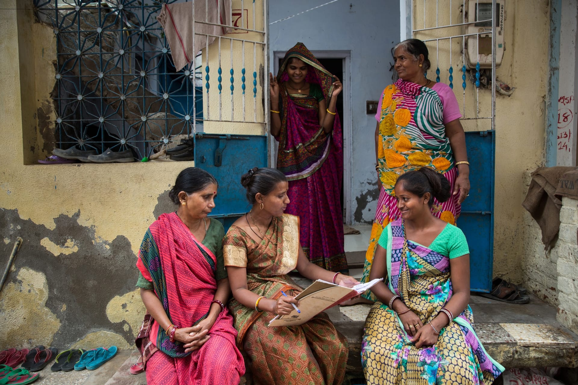 <p>Women gather outside their homes in Ahmedabad, India to discuss work issues. As organized home-based workers, the women associated are with the Self Employed Women’s Association (SEWA).</p>

