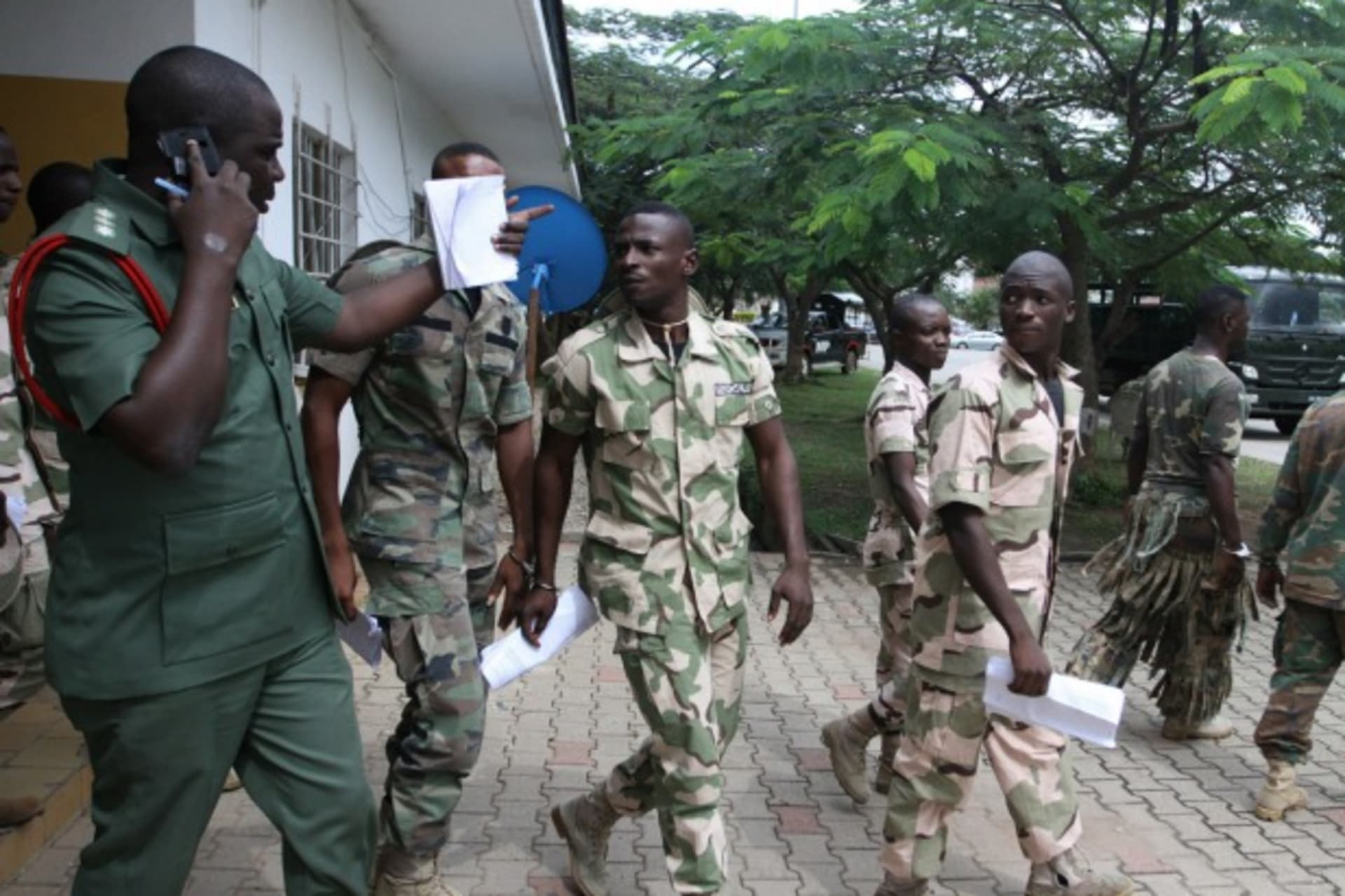 <p>Nigerian soldiers, handcuffed in pairs, leave the court premises after the opening of the General court-martial in Abuja October 2, 2014. </p>
