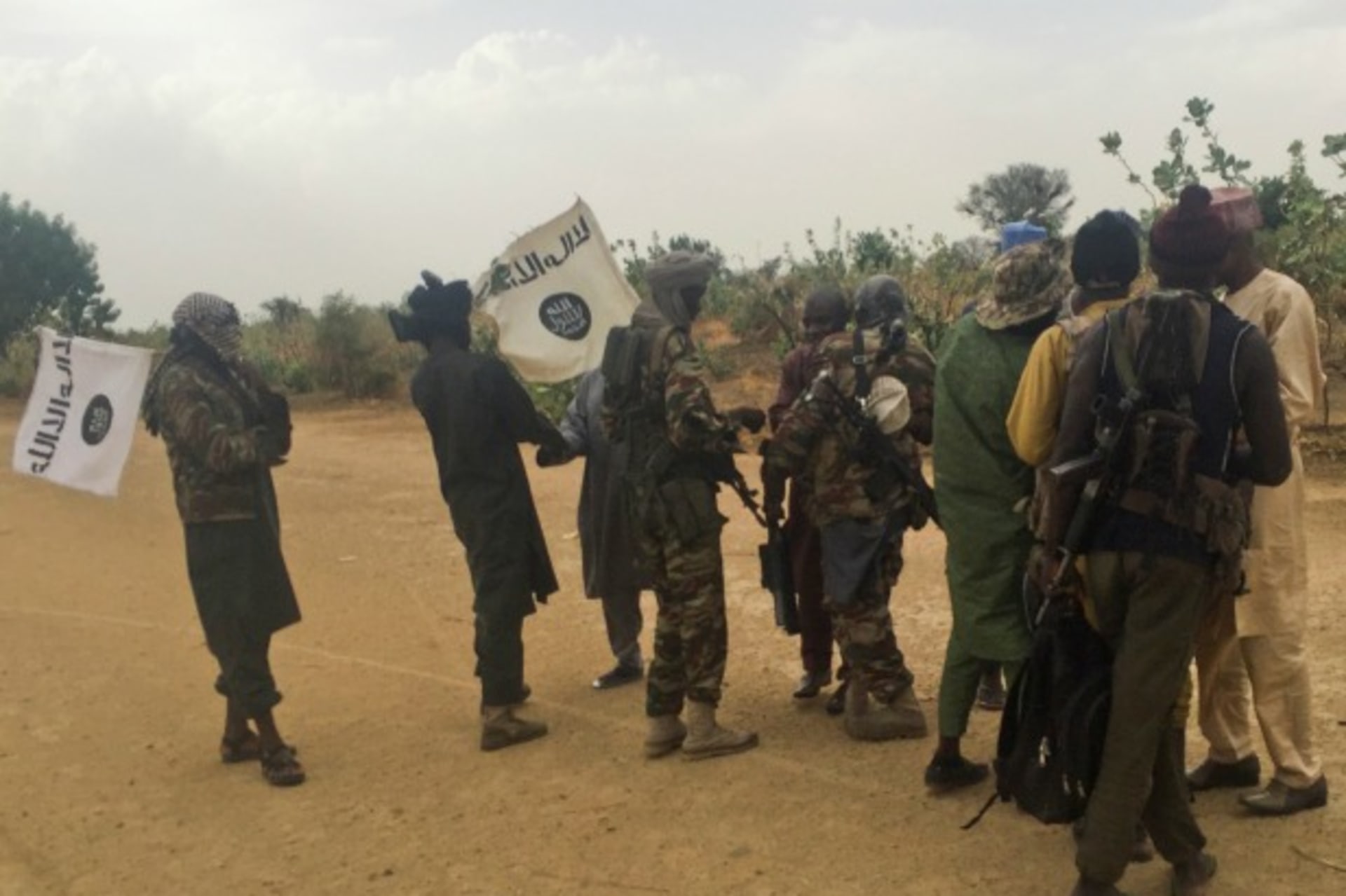 <p>Boko Haram militants (in camouflage) embrace and shake hands with Boko Haram prisoners, released in exchange for a group of 82 Chibok girls, who were held captive for three years by Islamist militants, near Kumshe, Nigeria, May 6, 2017.</p>
