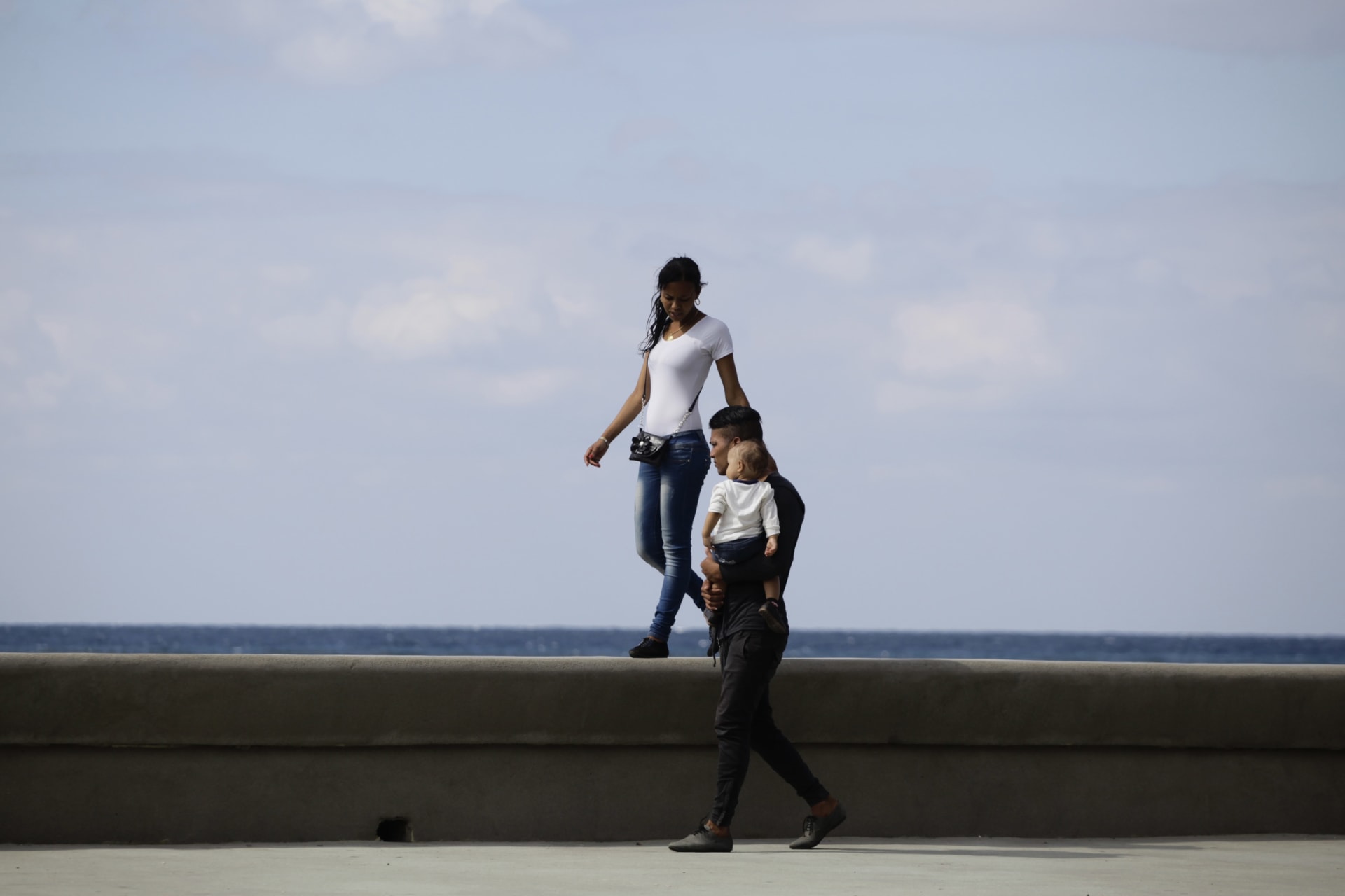 <p>A young couple walks with their baby on Havana’s El Malecon seafront bolulevard (March 28, 2013) </p>