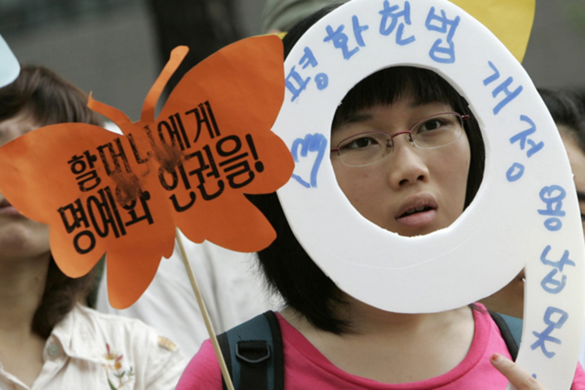 <p>A protester holding signs participates in an anti-Japan rally to solve the issue of comfort women, who served the Japanese military during World War Two, in front of the Japanese Embassy in Seoul on July 25, 2007. </p>

