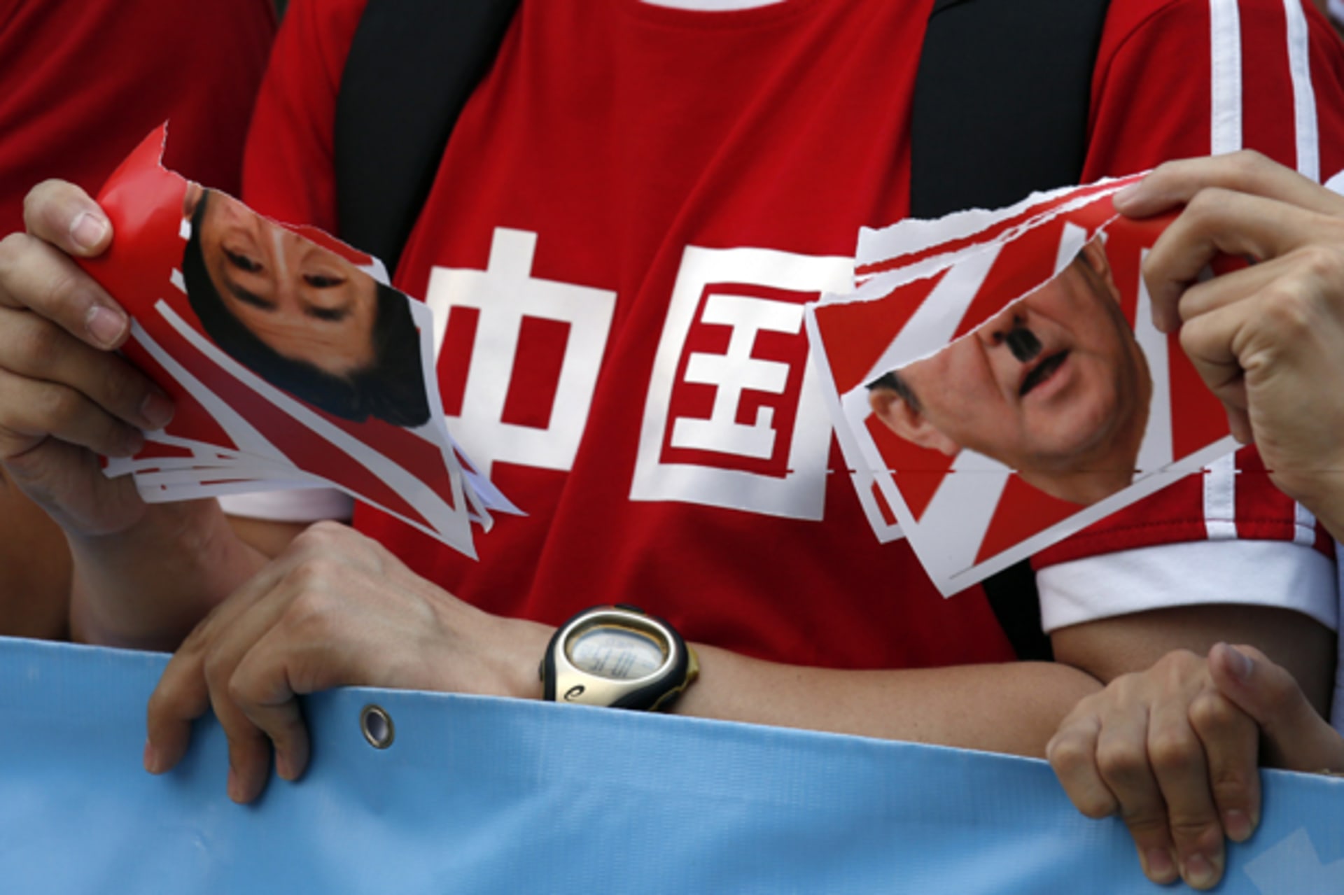 <p>Protesters tear a defaced portrait of Japan’s Prime Minister Shinzo Abe during a demonstration outside the Japanese consulate in Hong Kong on September 3, 2014. he characters on the T-shirt read, “China”.</p>
