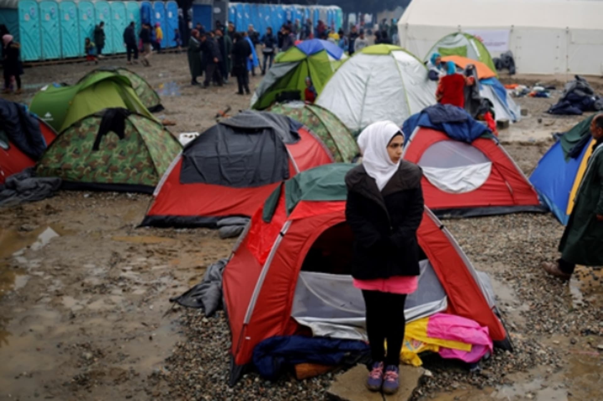 <p>A migrant woman stands outside a tent at a makeshift camp on the Greek-Macedonian border.</p>
