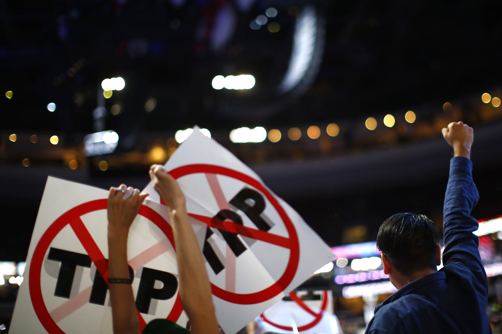 <p>Delegates protesting against the Trans Pacific Partnership (TPP) trade agreement hold up signs. </p>
