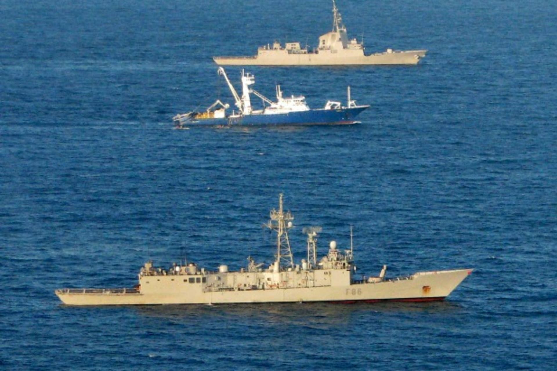 <p>The Spanish tuna fishing boat Alakrana sails between two accompanying Spanish warships in the Indian ocean after it was freed from Somali pirates November 17, 2009. </p>
