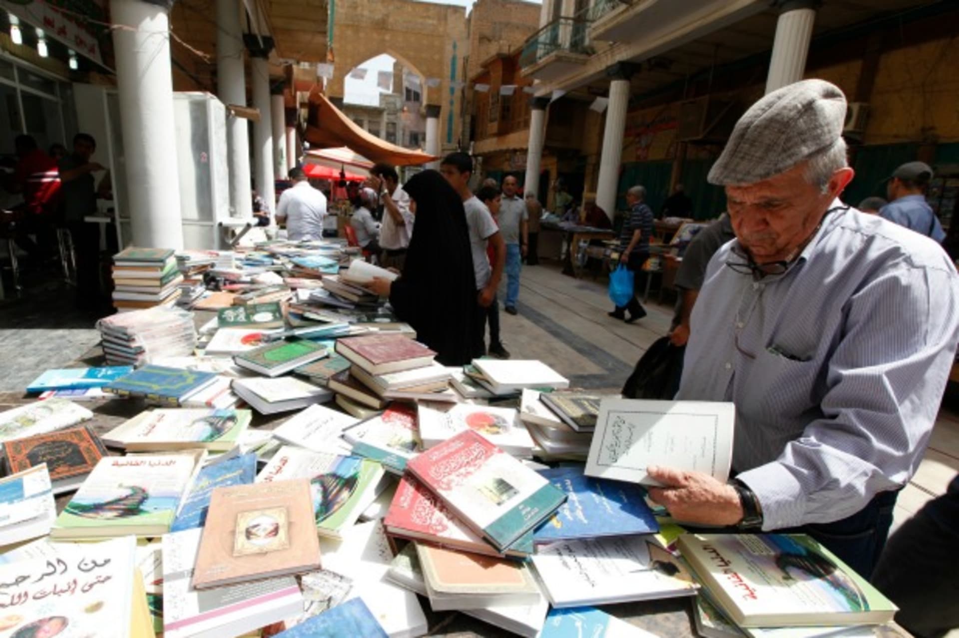 <p>Residents shop for books at Mutanabi Street in Baghdad (Ahmed Saad/Reuters).</p>
