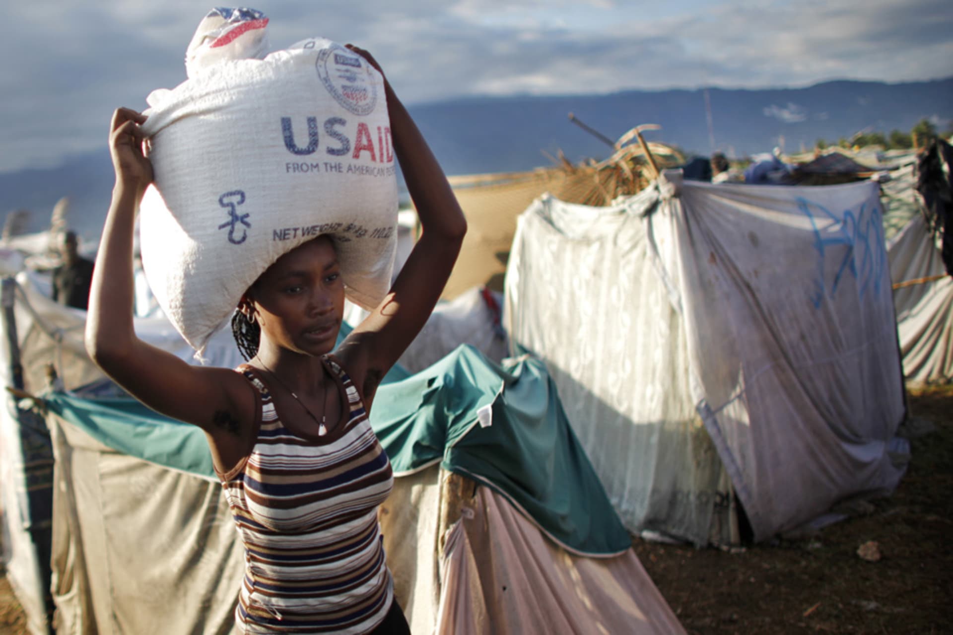 <p>A woman carries a bag of rice distributed by the U.S. Agency for International Development (USAID) in Port-au-Prince, Haiti. </p>
