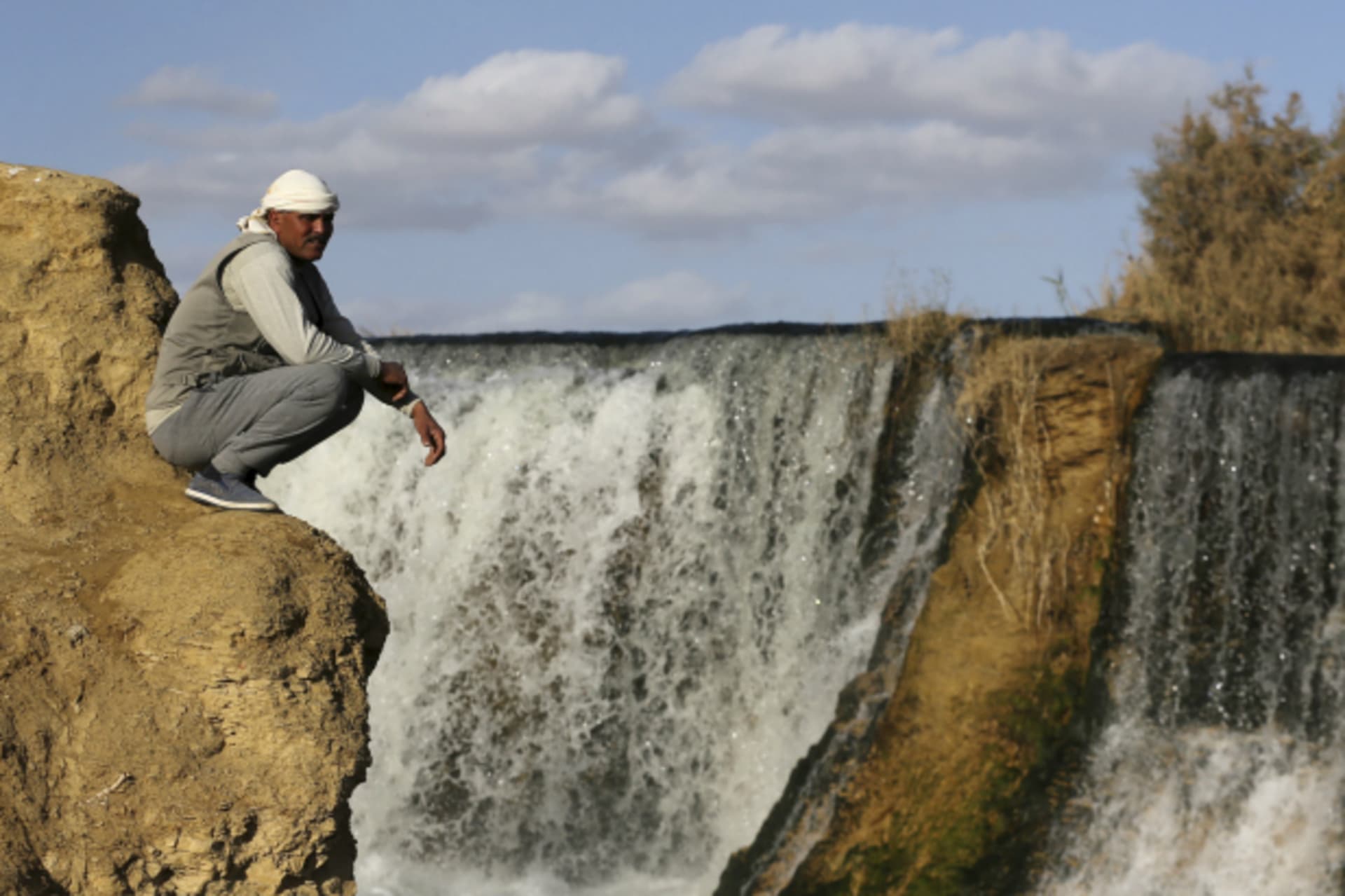 <p>A man sits near the waterfall at Wadi El-Rayan in the Al Fayoum Governorate, southwest of Cairo, Egypt (Mohamed Abd El Ghany/Reuters).</p>
